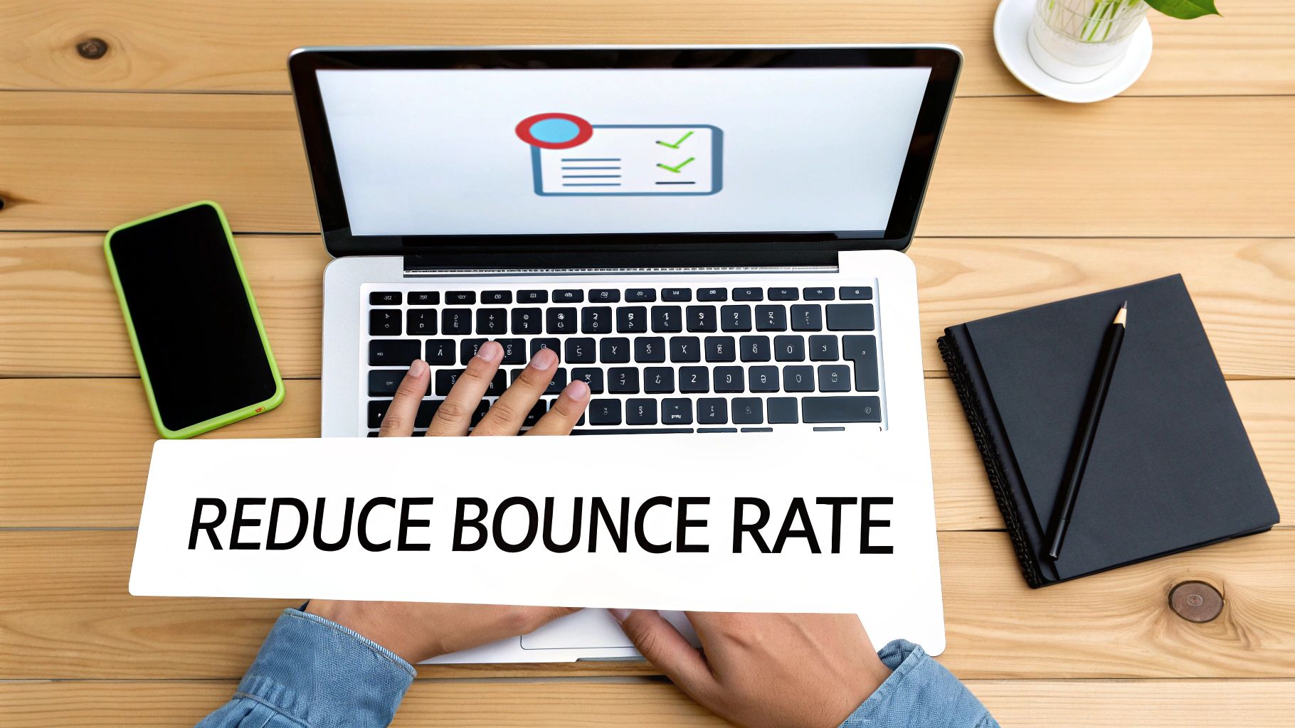 Hands typing on a laptop with 'REDUCE BOUNCE RATE' text, smartphone, and notebook on a wooden desk.