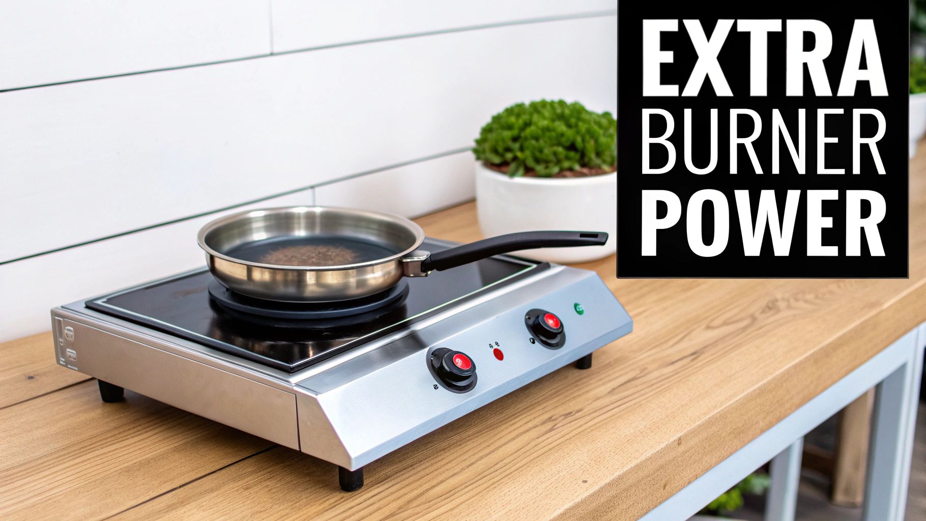 A stainless steel pan on a two-burner silver electric hot plate sits on a wooden counter.