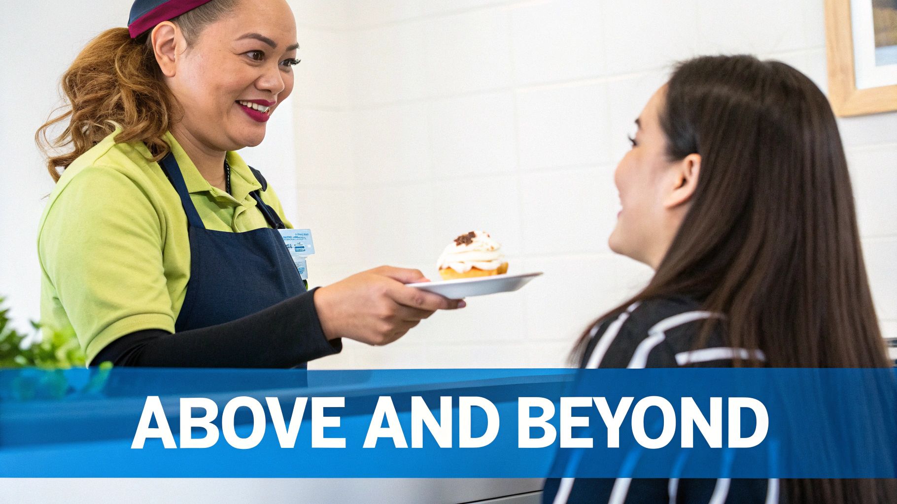 A smiling service worker in an apron serves a delicious cupcake to a happy customer.