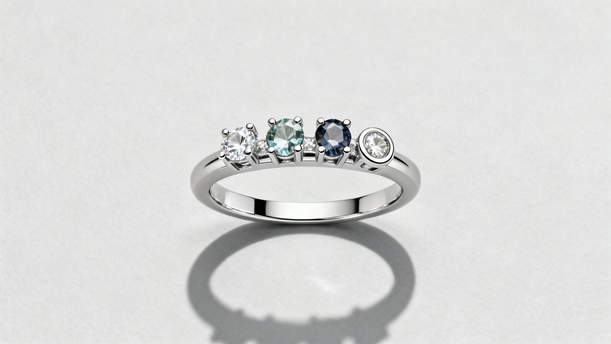 A beautifully designed mother ring with multiple birthstones in a person's hand.