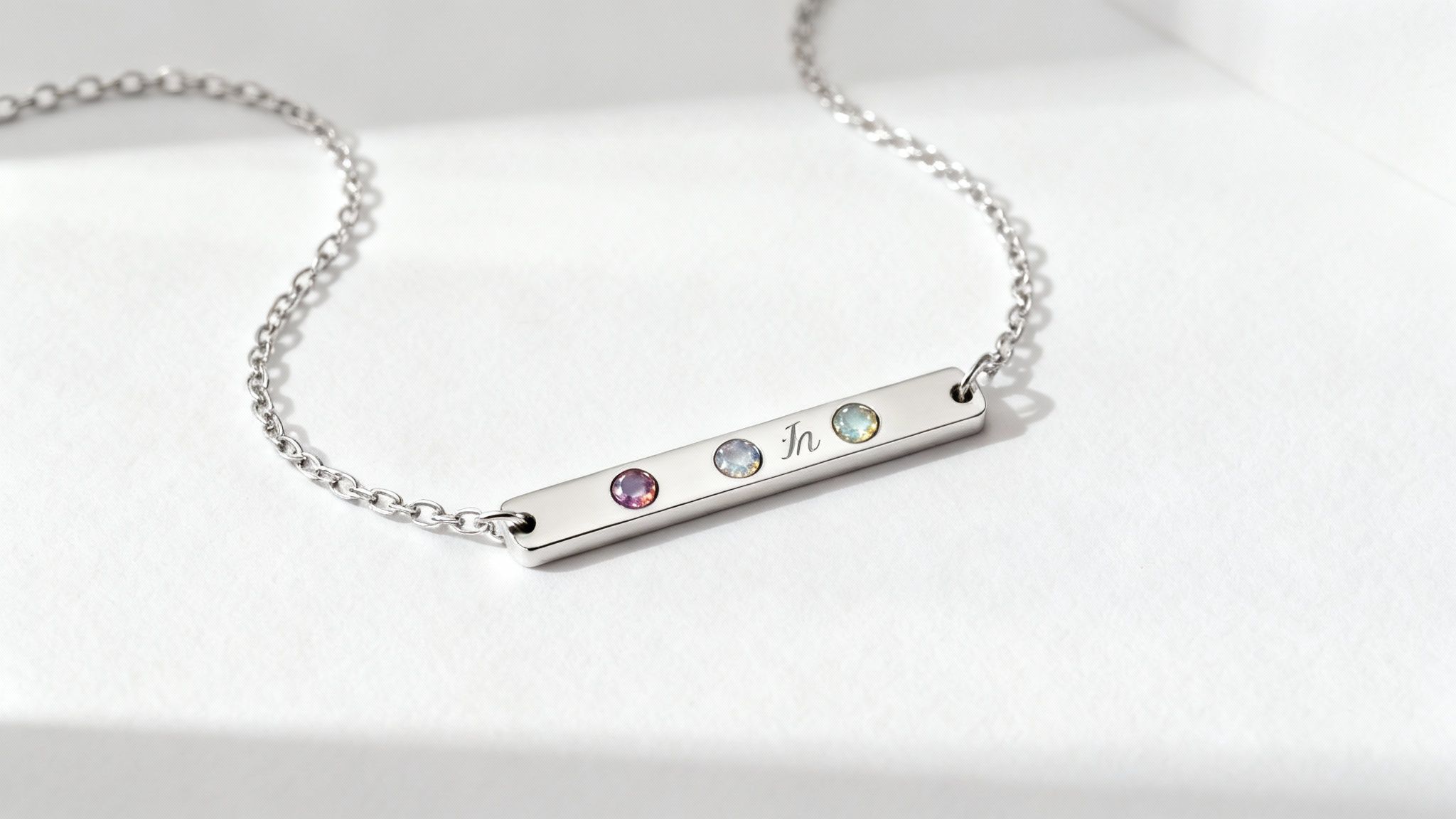 A close-up of a personalized bar necklace with birthstones, showing detail and craftsmanship.