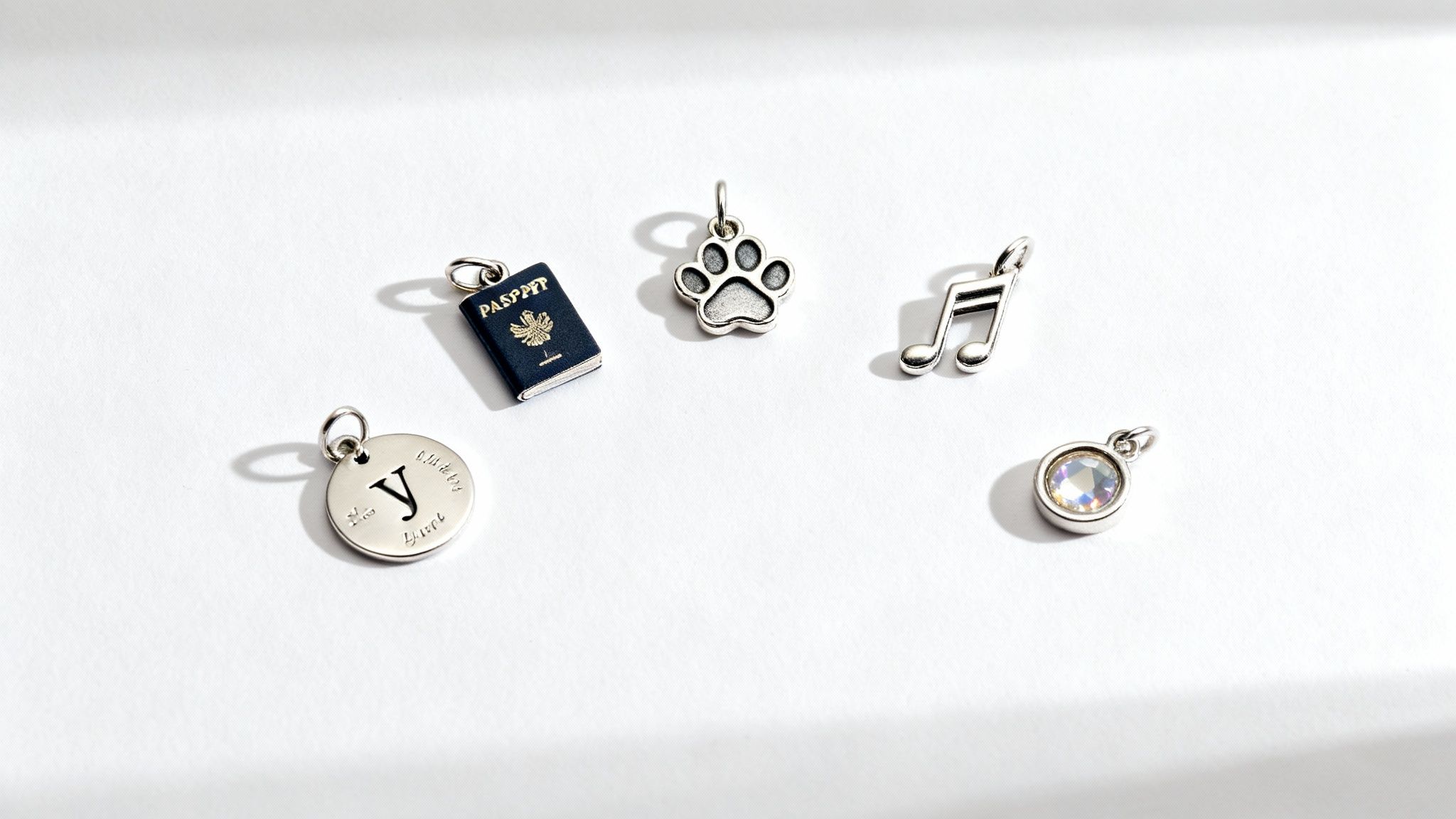 A hand holding a charm bracelet with various meaningful charms.