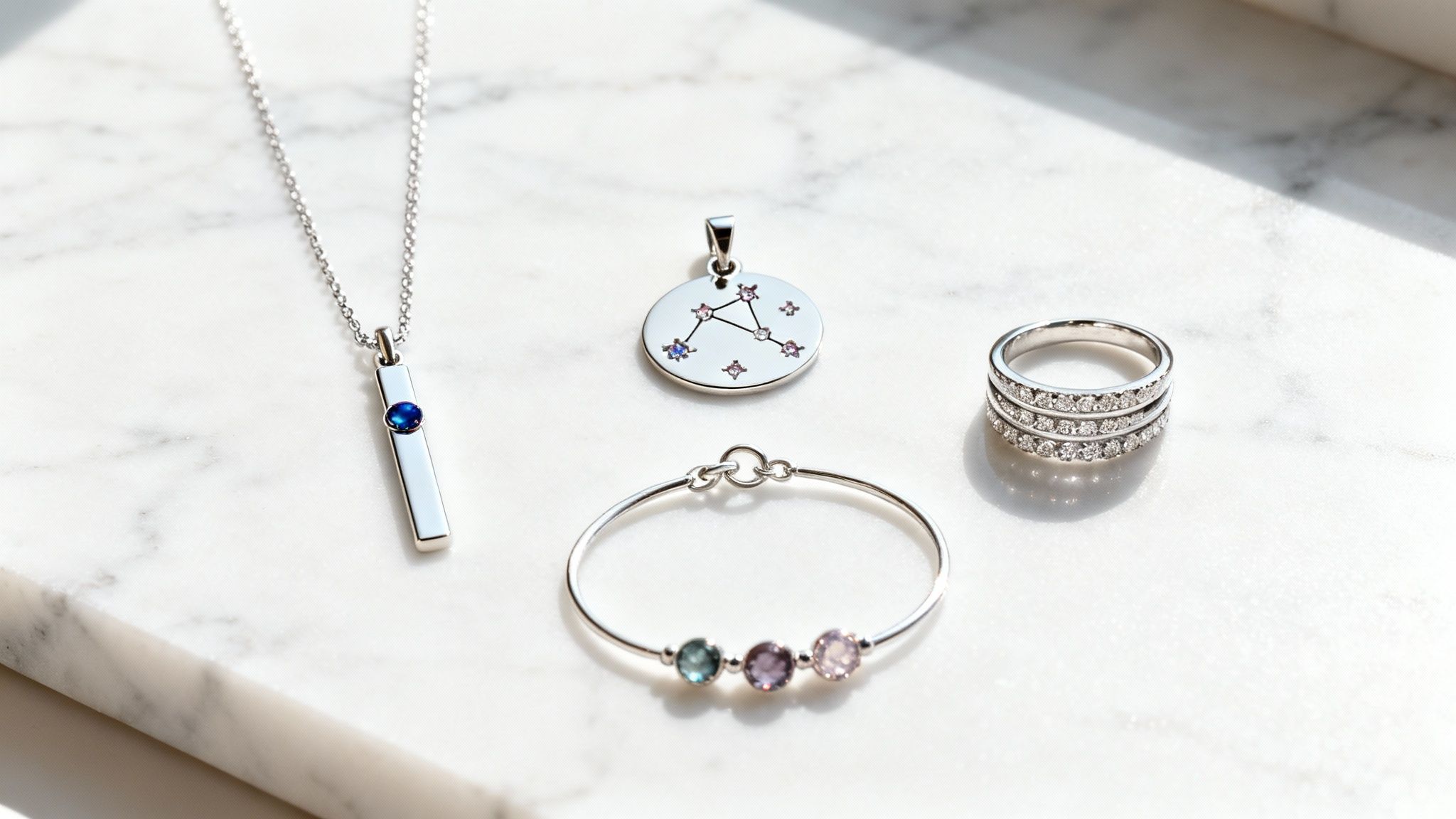 Collection of personalized silver jewelry including birthstone necklaces, constellation pendant, gemstone bracelet and diamond rings
