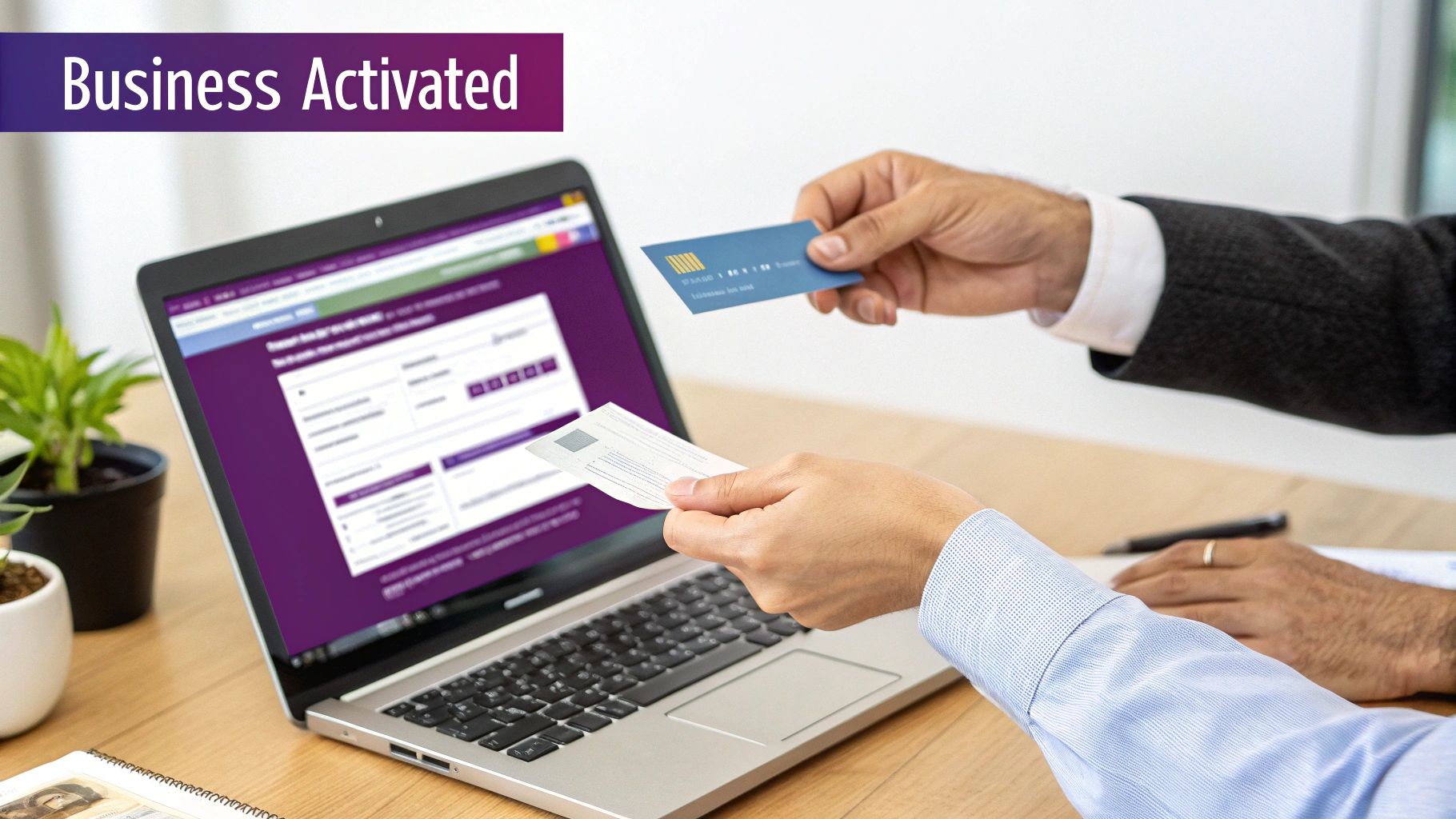 Hands exchanging cards over a laptop displaying a "Business Activated" screen.