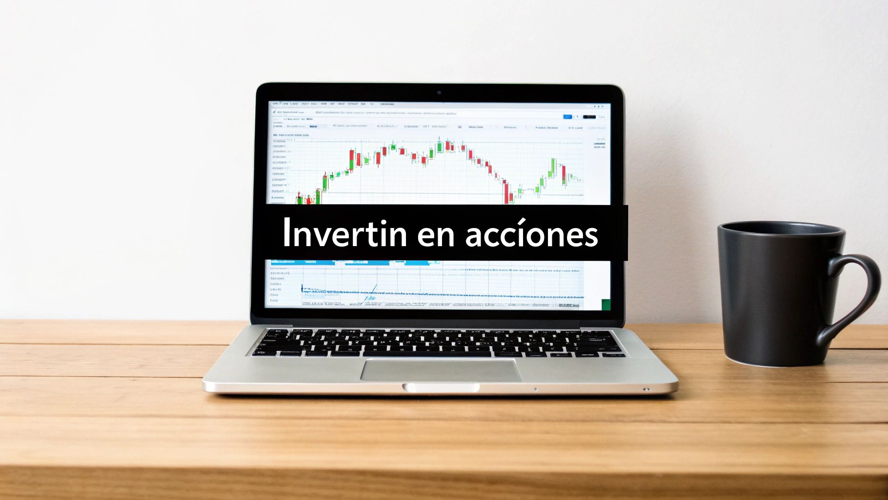 Portátil mostrando gráficos bursátiles y texto Invertir en acciones sobre mesa de madera con taza de café