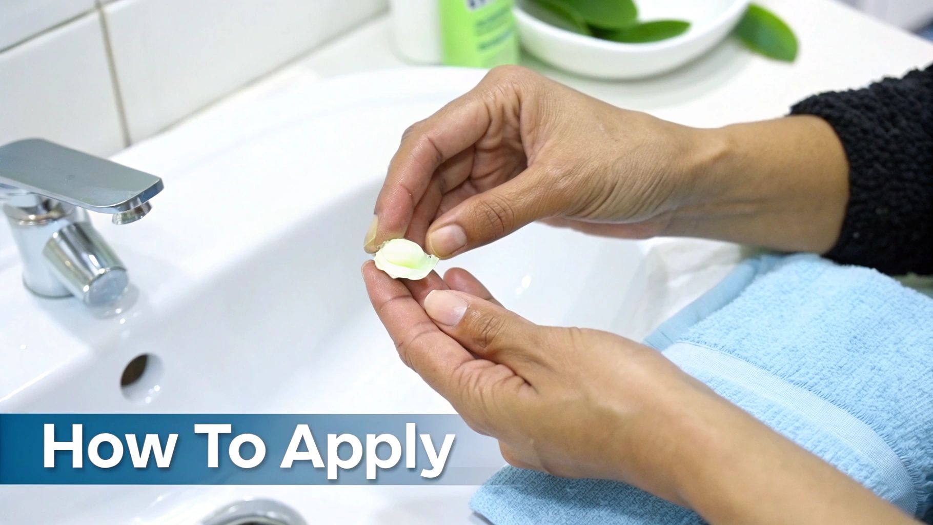 Close-up of hands holding a small, light green capsule or cream product over a bathroom sink, with text overlay "How To Apply".