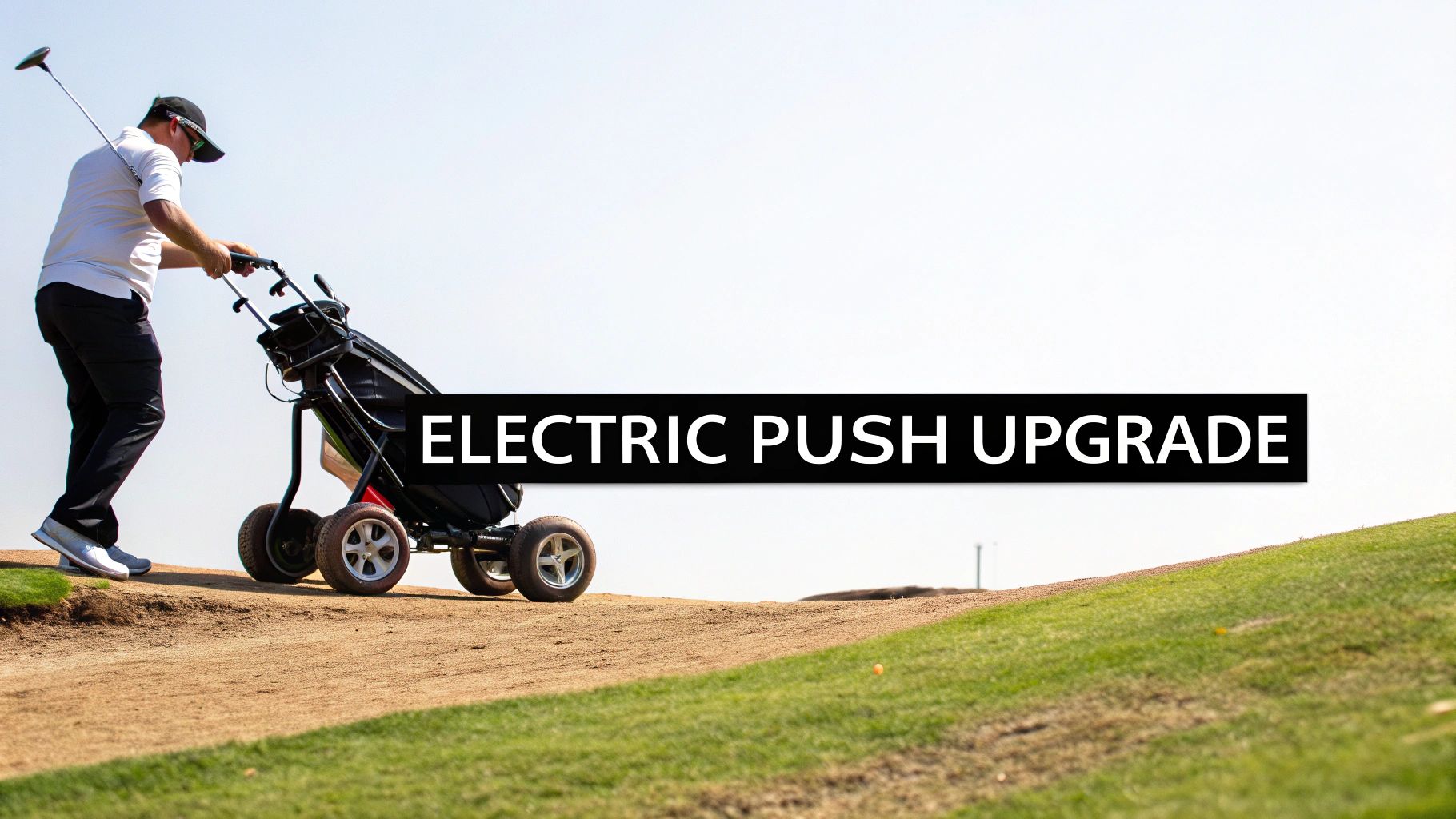 A golfer pushes an electric golf cart up a sandy path on a sunny golf course.