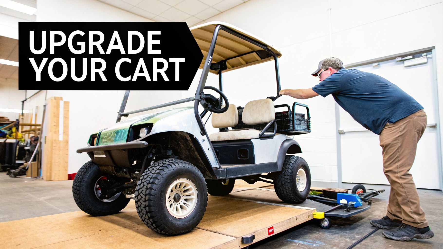 A standard golf cart being fitted with larger, aggressive off-road tires in a garage.