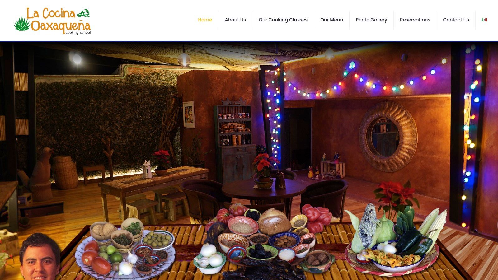 Participants at La Cocina Oaxaqueña smiling as they learn to prepare traditional Oaxacan dishes in a home-style kitchen.