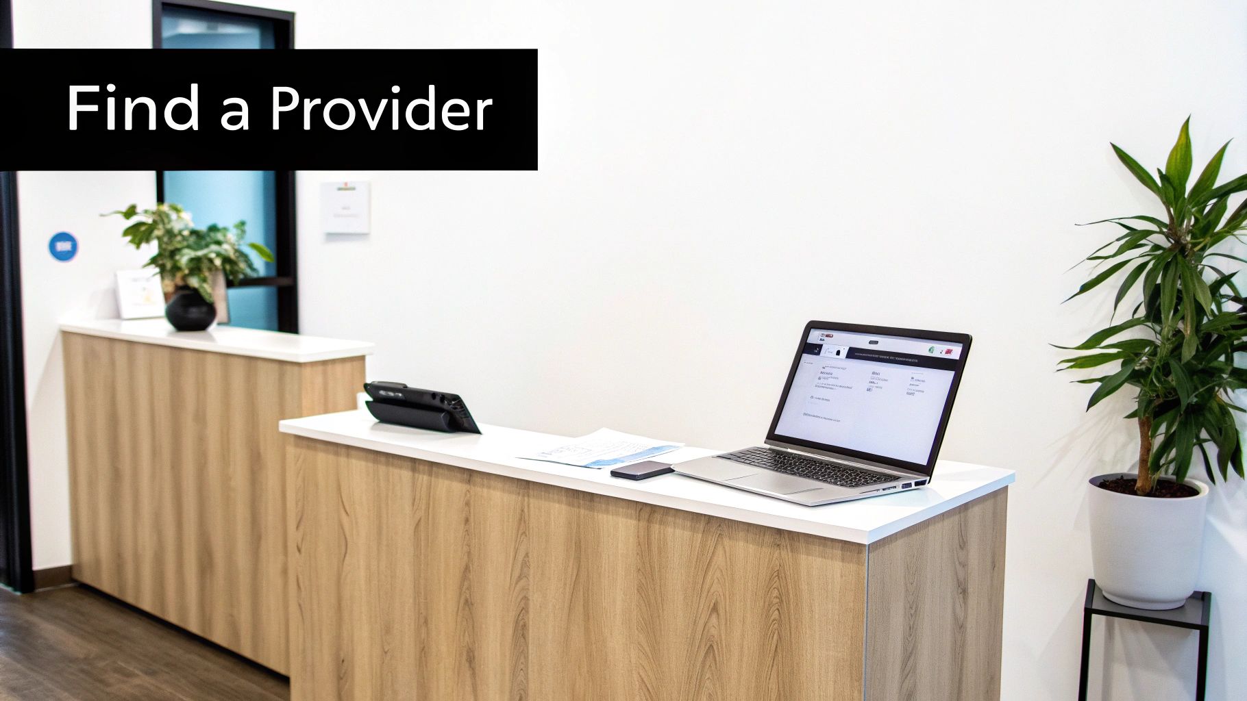 Modern medical office reception desk with laptop computer displaying healthcare provider search interface