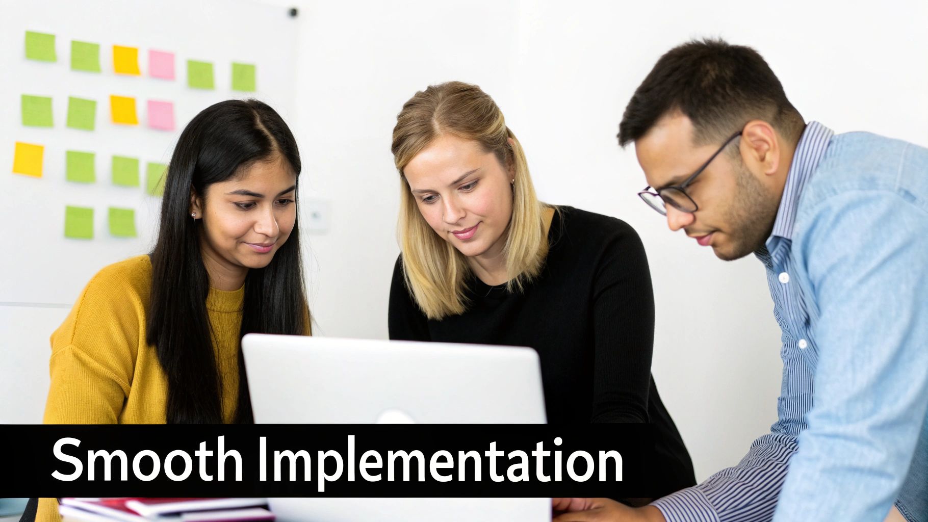 A team collaborating around a computer screen during a software implementation meeting