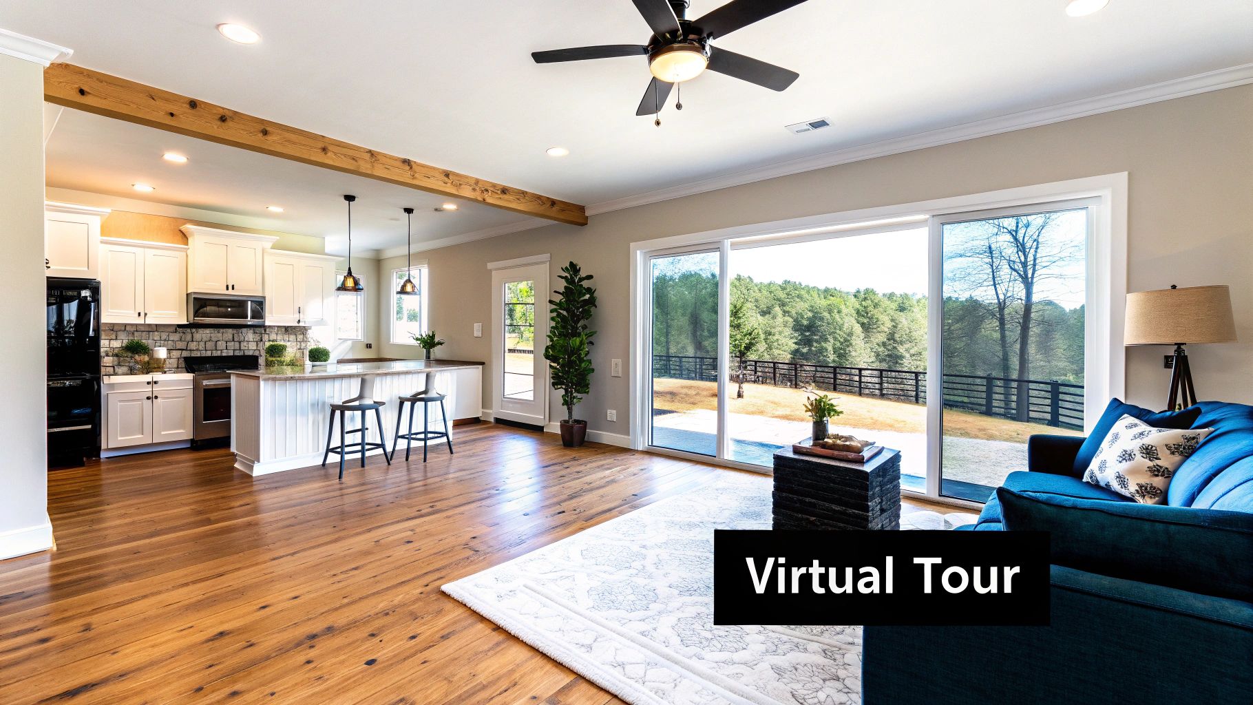 An open-concept modern home featuring a white kitchen, hardwood floors, and a bright living room with outdoor views.