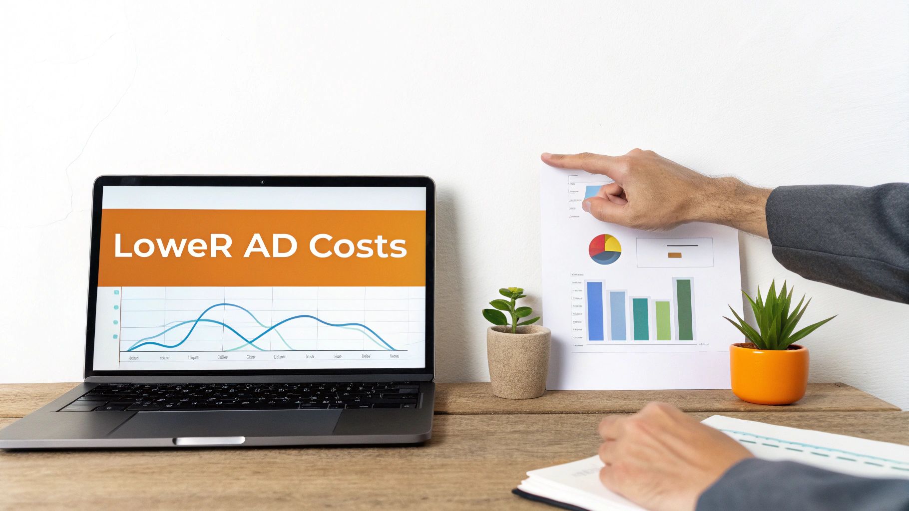 A person points at business charts, with a laptop screen displaying 'Lower AD Costs' and a line graph.