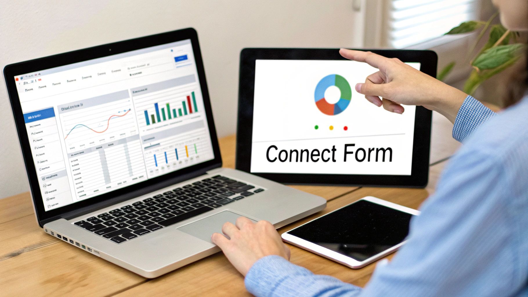 Person pointing at tablet displaying Connect Form with pie chart while using laptop with analytics dashboard