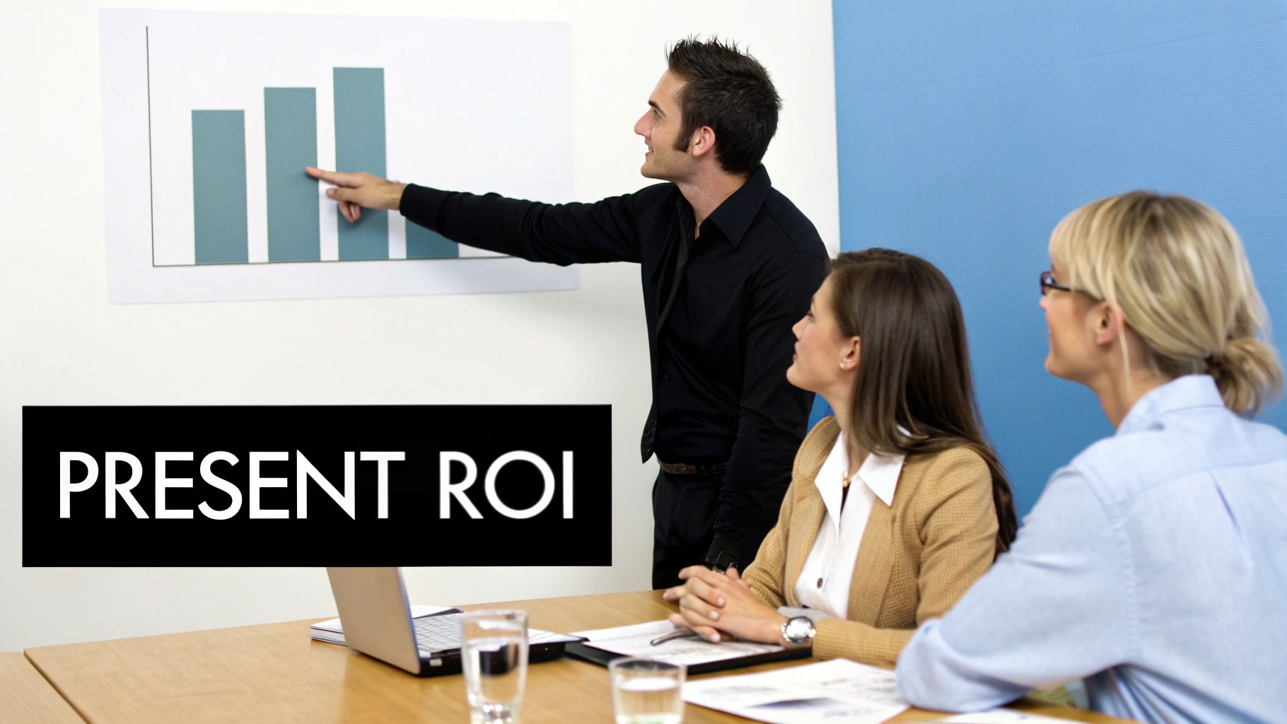 A man presents a bar graph on ROI to two women in a business meeting.