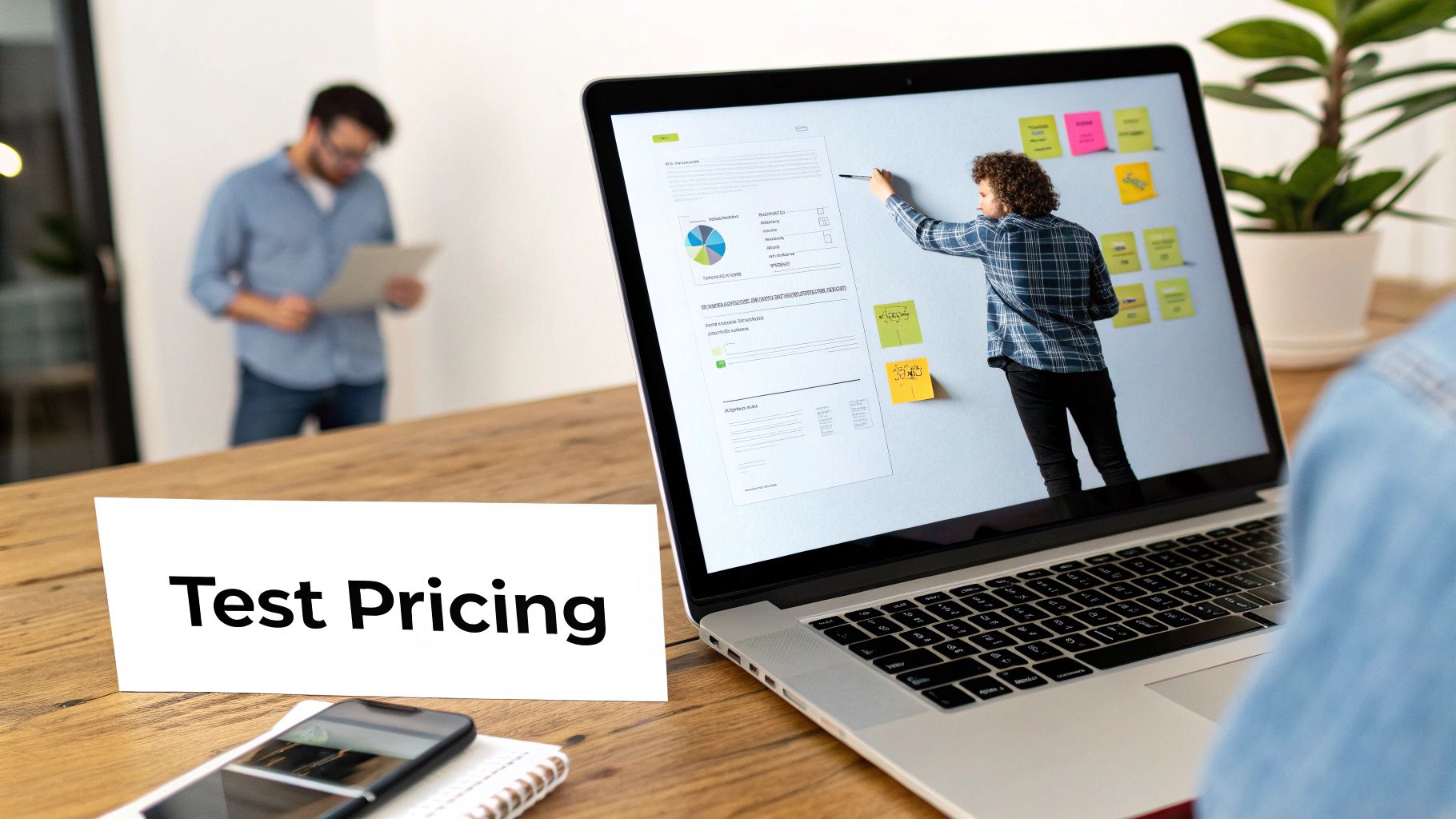 Business team conducting test pricing strategy meeting with laptop displaying charts and sticky notes