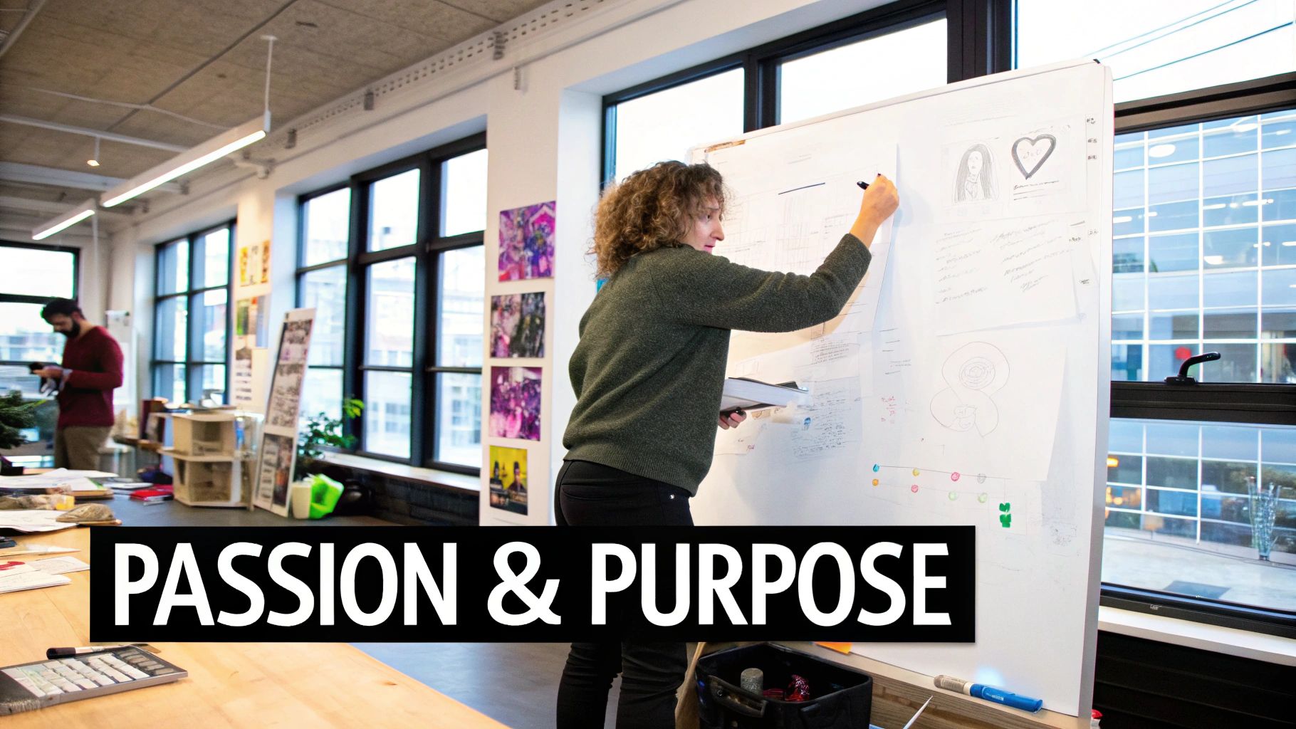 Woman writing on a whiteboard in a collaborative workspace, emphasizing passion and purpose in entrepreneurship, with notes and sketches visible in the background.
