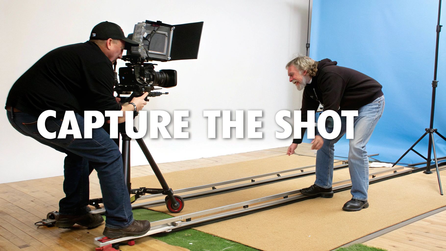 Filmmakers capture a shot with a professional camera on a dolly track in a studio.