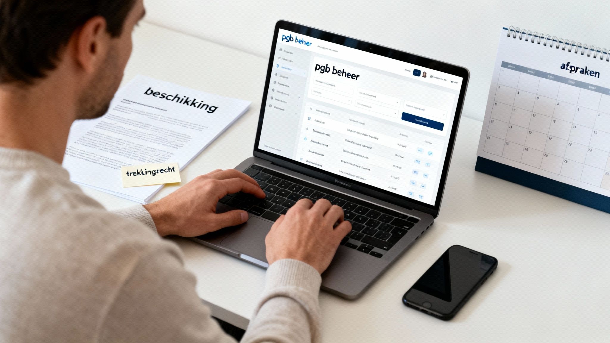 Man werkt aan laptop met pgb beheersoftware, documenten en een afsprakenkalender op zijn bureau.
