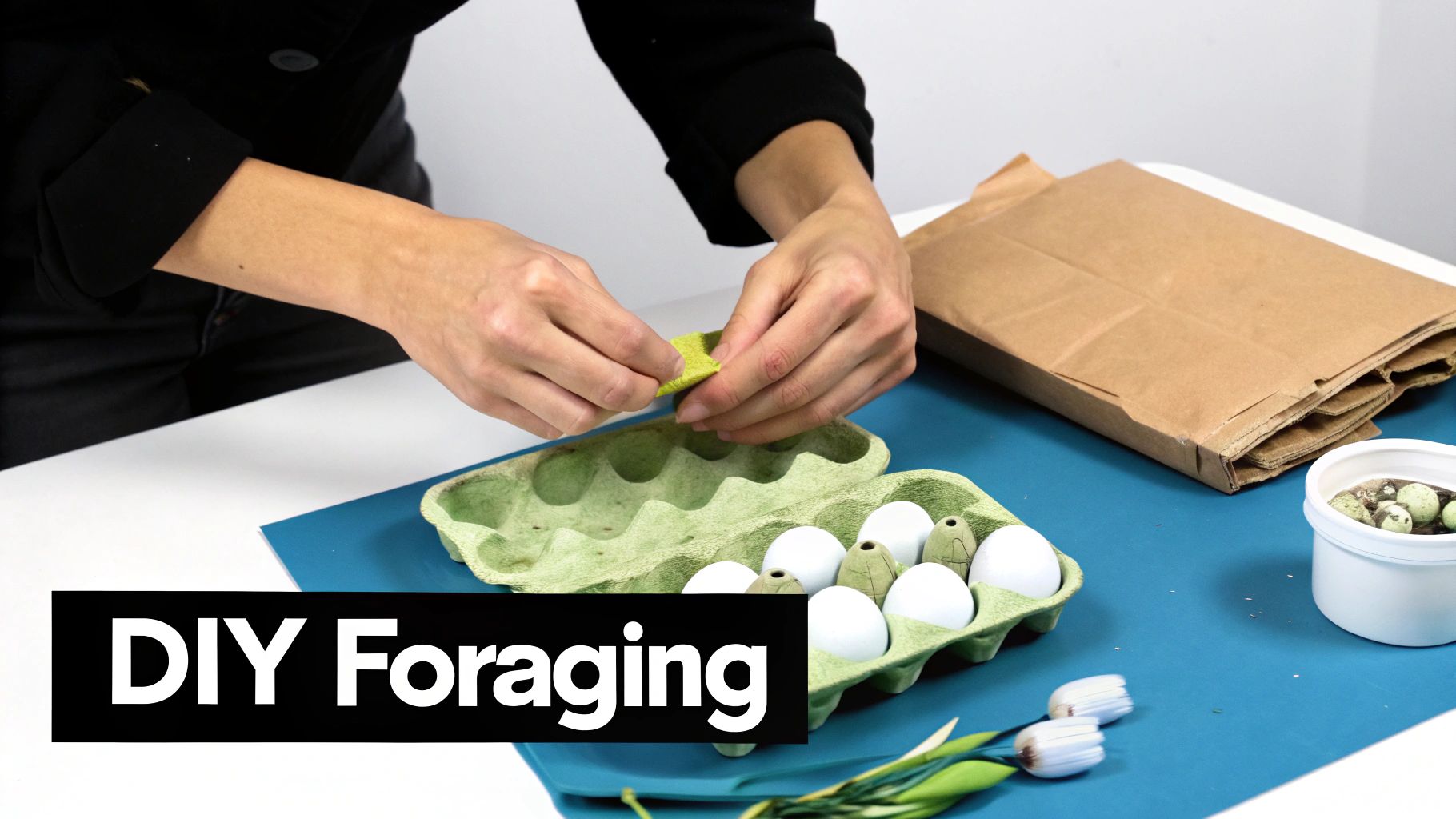 Close-up of hands placing green felt into an egg carton with white and decorative eggs for a DIY foraging activity.