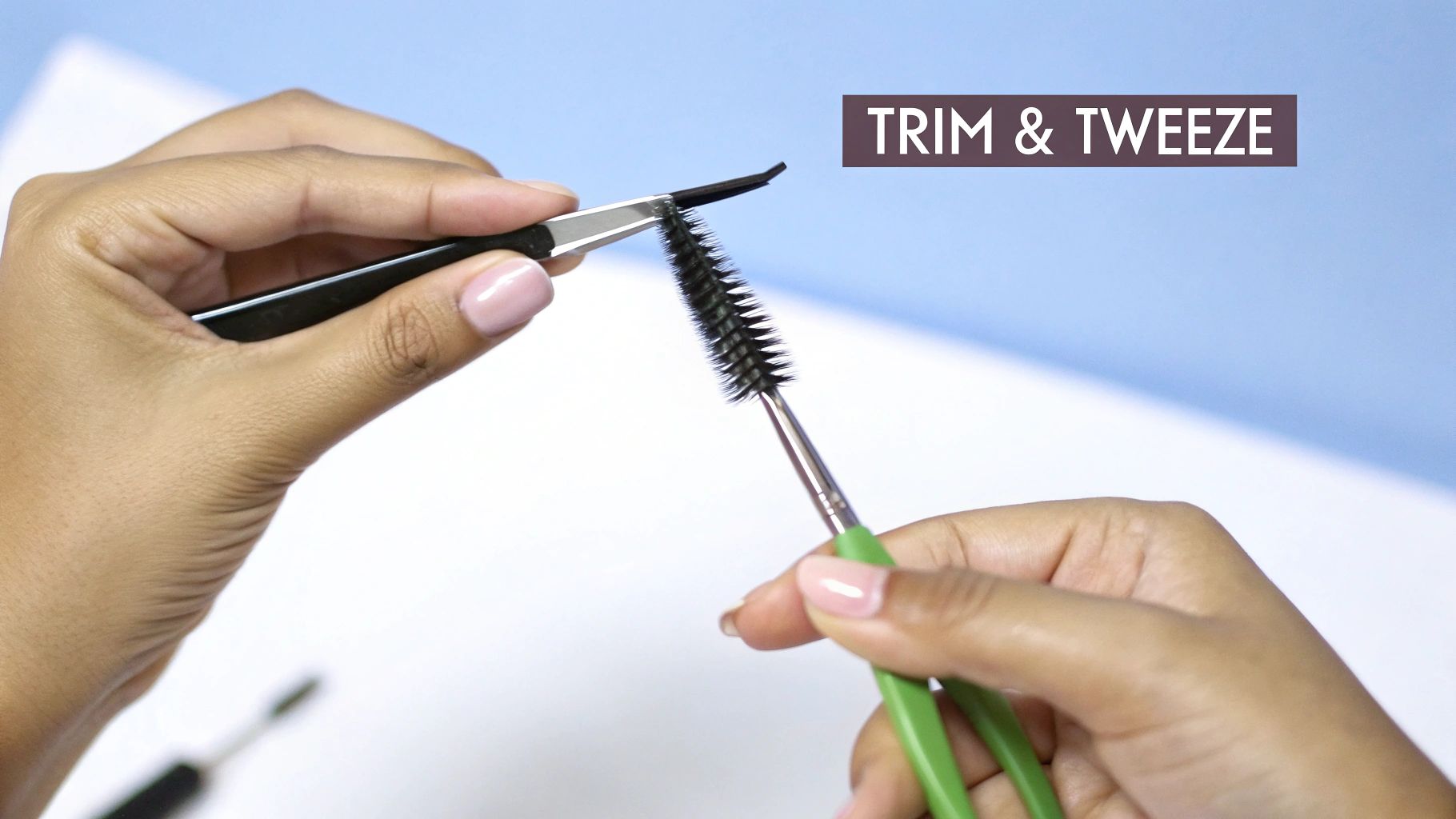 A woman carefully tweezing her eyebrows in a well-lit mirror