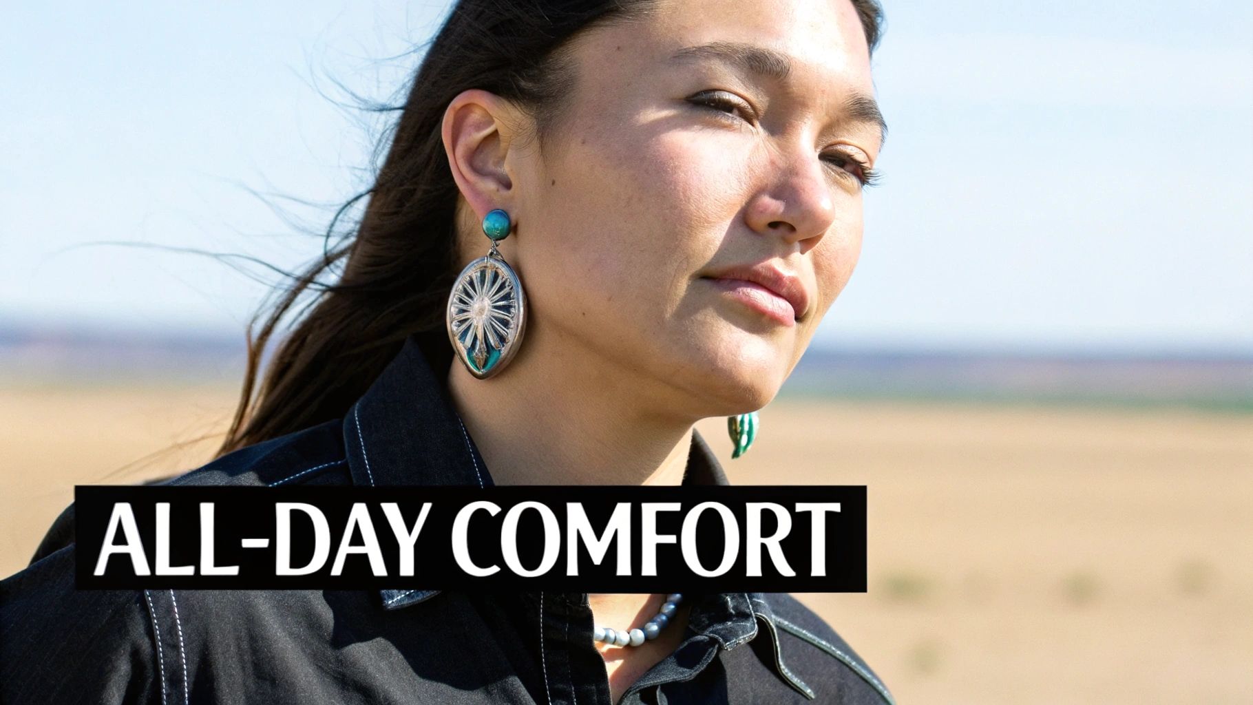 Close-up of a woman in dark denim with large silver and turquoise earrings outdoors.
