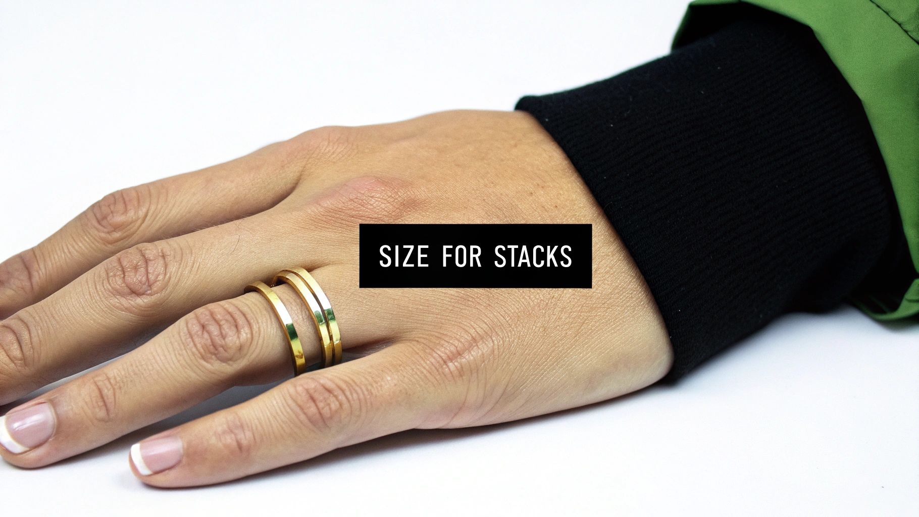 Close-up of a hand wearing two gold stacking rings, with 'SIZE FOR STACKS' text.
