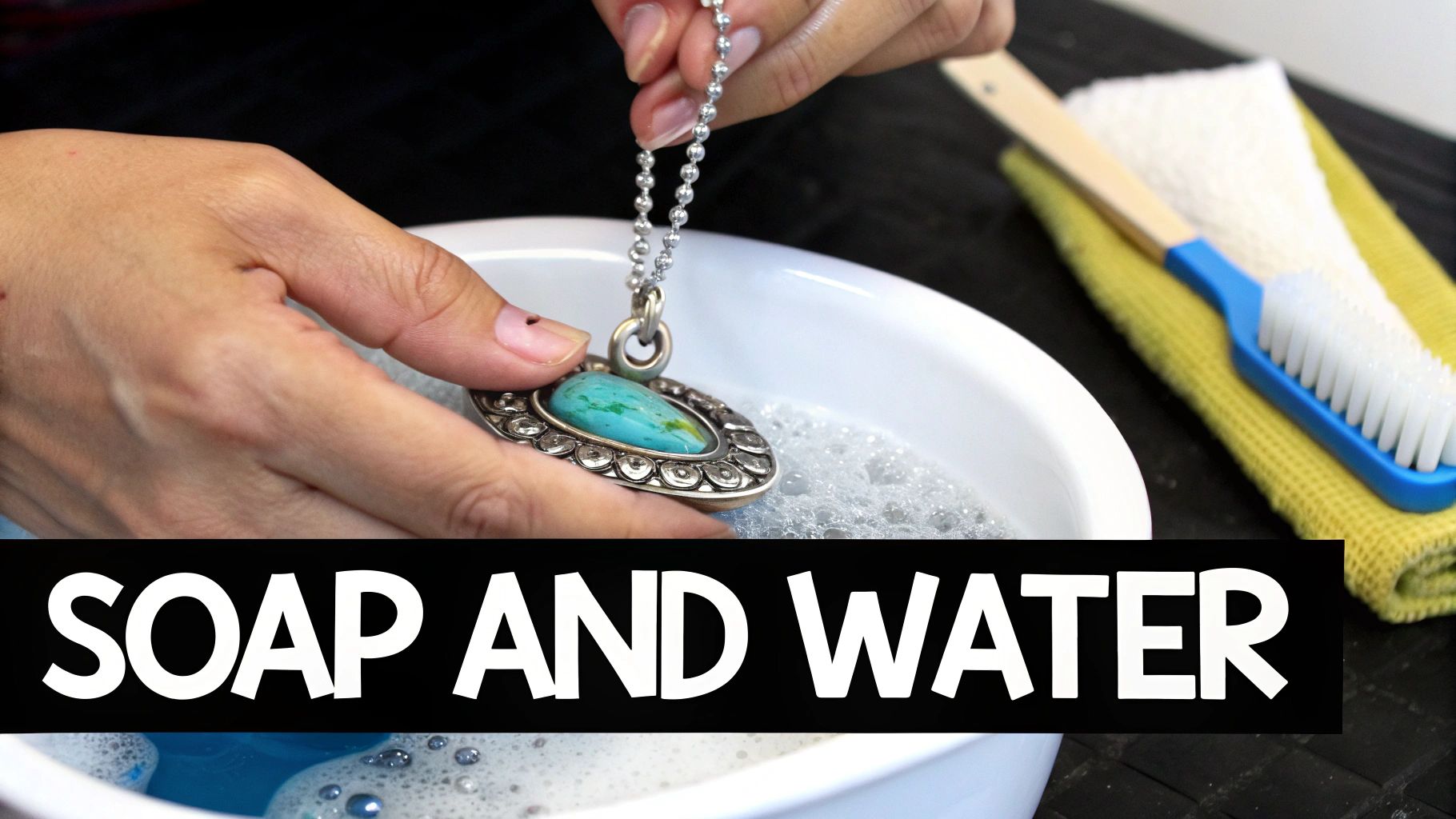 A close-up of sterling silver jewelry soaking in a small bowl of soapy water.