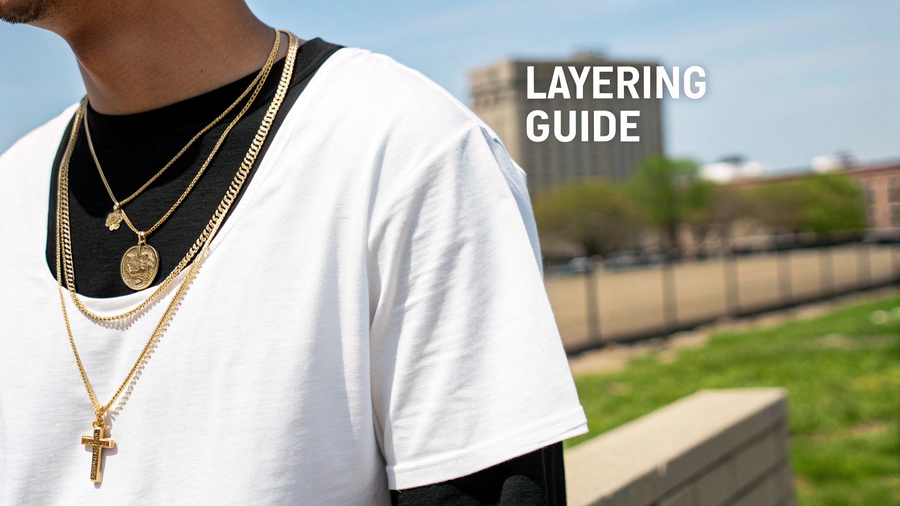 Close-up of a person wearing multiple gold layered necklaces, including a cross and medallion pendant.