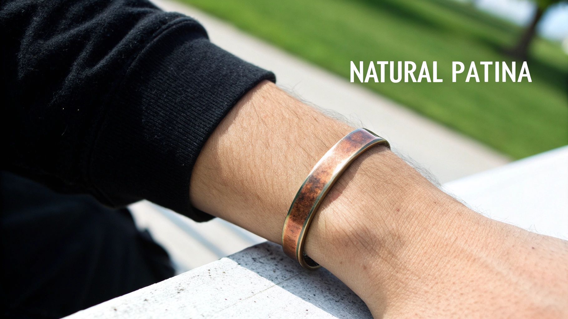 A close-up shot of a Southwestern-style copper cuff bracelet resting on a rustic wooden surface.