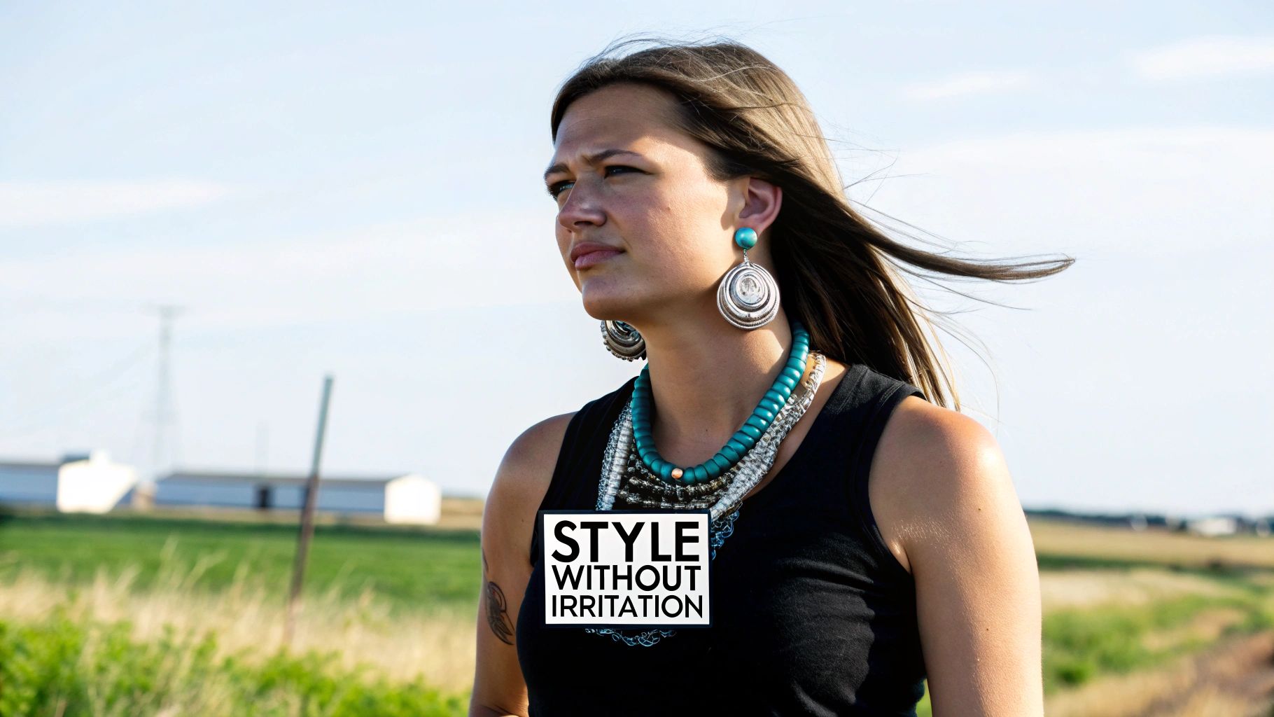 A woman outdoors wearing large silver spiral earrings and a layered turquoise bead necklace.