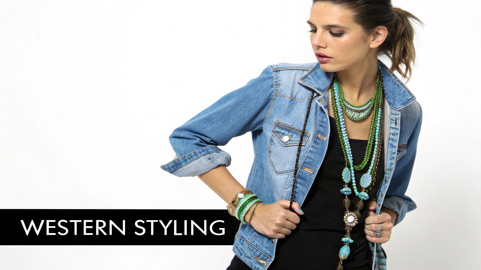 A woman wearing a denim jacket and layered turquoise and green western-style necklaces.