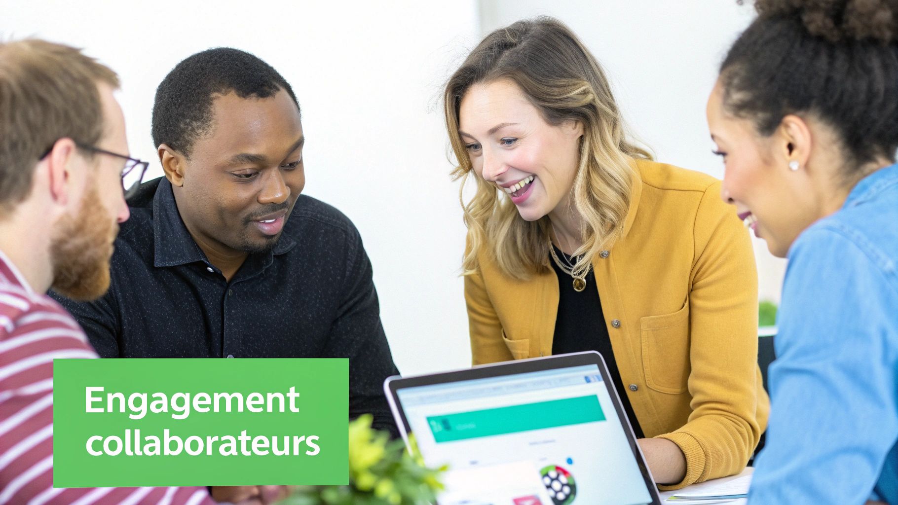 Quatre collaborateurs souriants autour d'un ordinateur portable, engagés dans une discussion collaborative. Texte: Engagement collaborateurs.