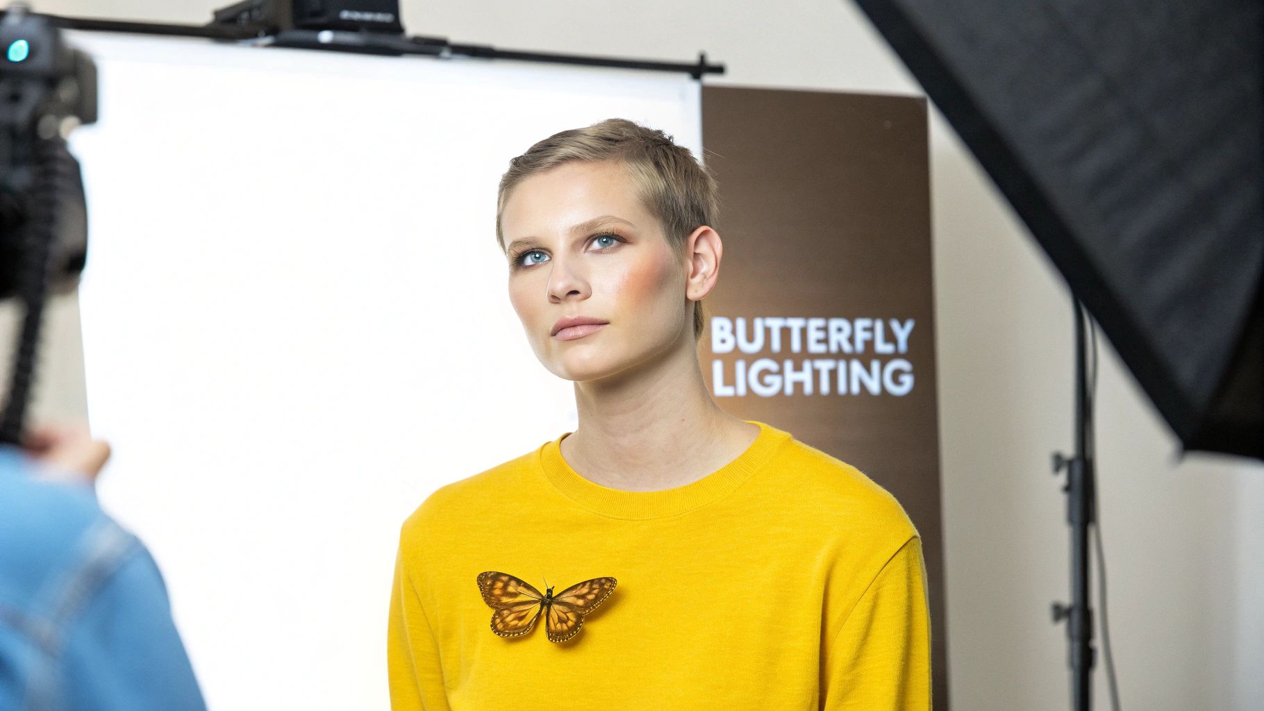 Female model in yellow shirt with butterfly pin posing for a headshot using butterfly lighting.
