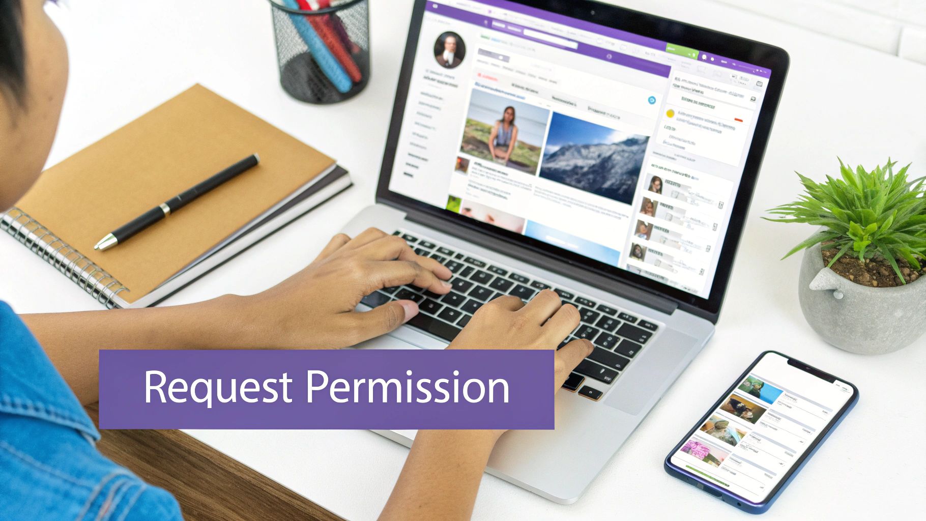 Person working on a laptop with a smartphone and notebook on a white desk, requesting permission.