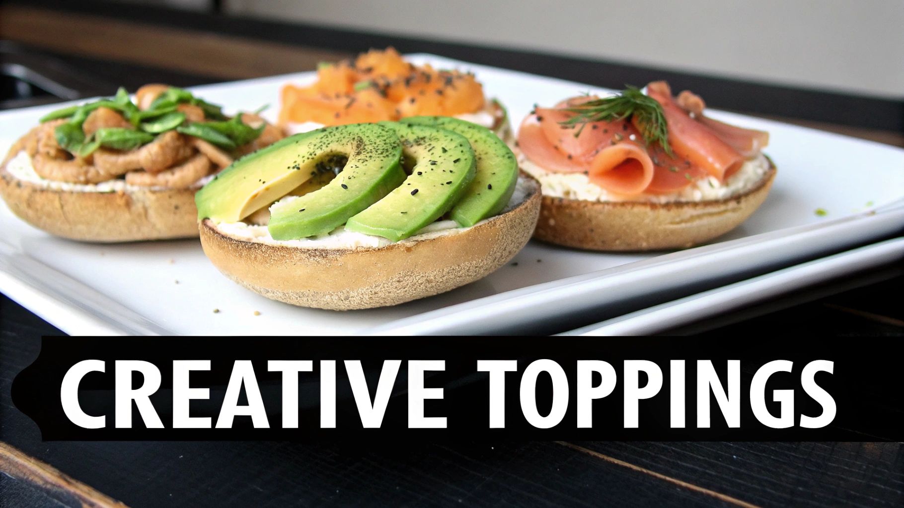 Four toasted bagel halves with creative toppings including avocado, salmon, mushrooms, and cream cheese