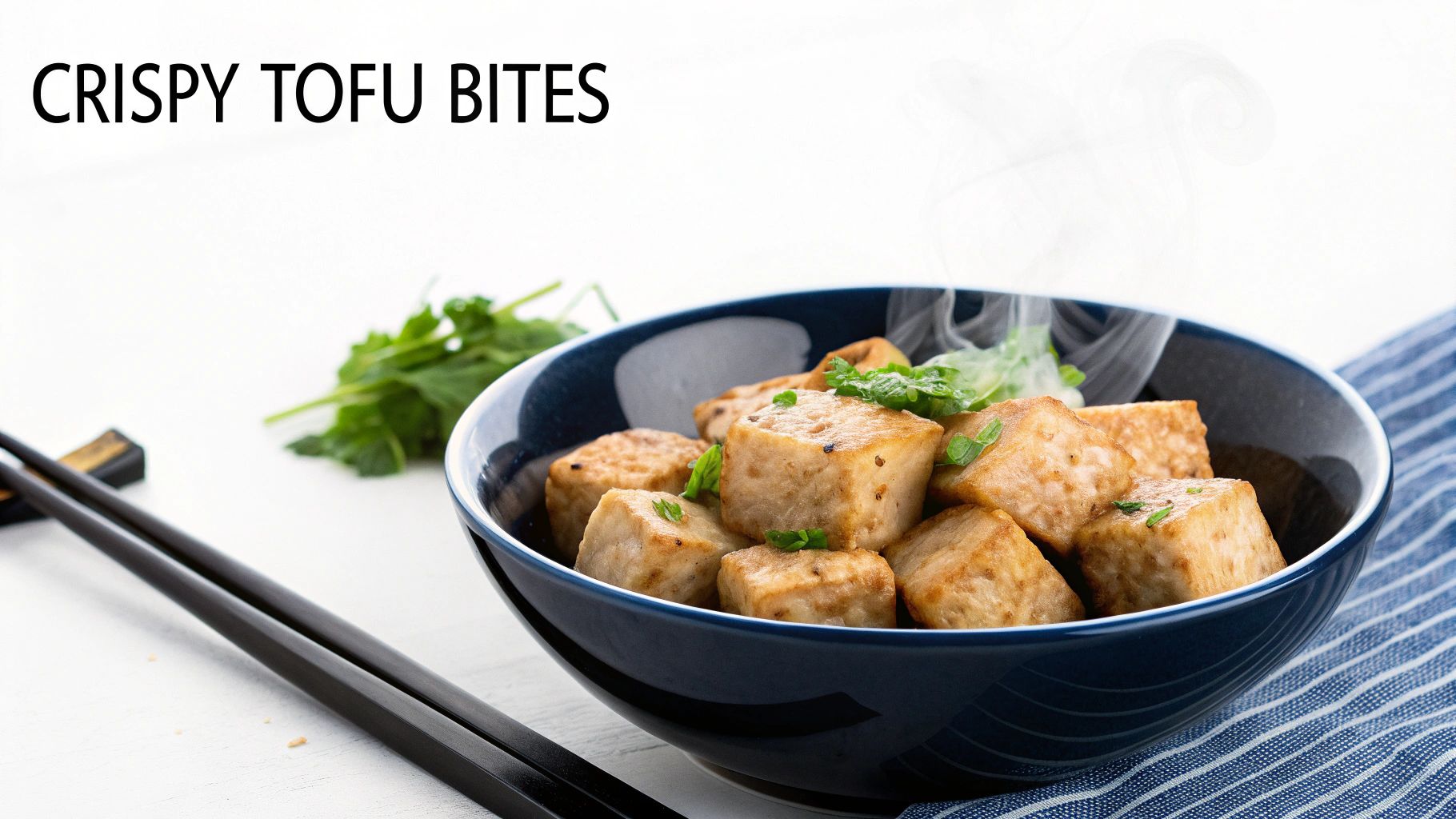 Close-up of crispy golden-brown tofu bites with steam rising, garnished with fresh green herbs in a blue bowl.