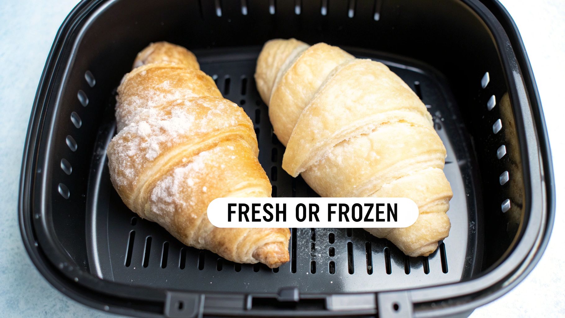 Two croissants, one appearing frozen, in a black air fryer basket, with 'Fresh or Frozen' text.