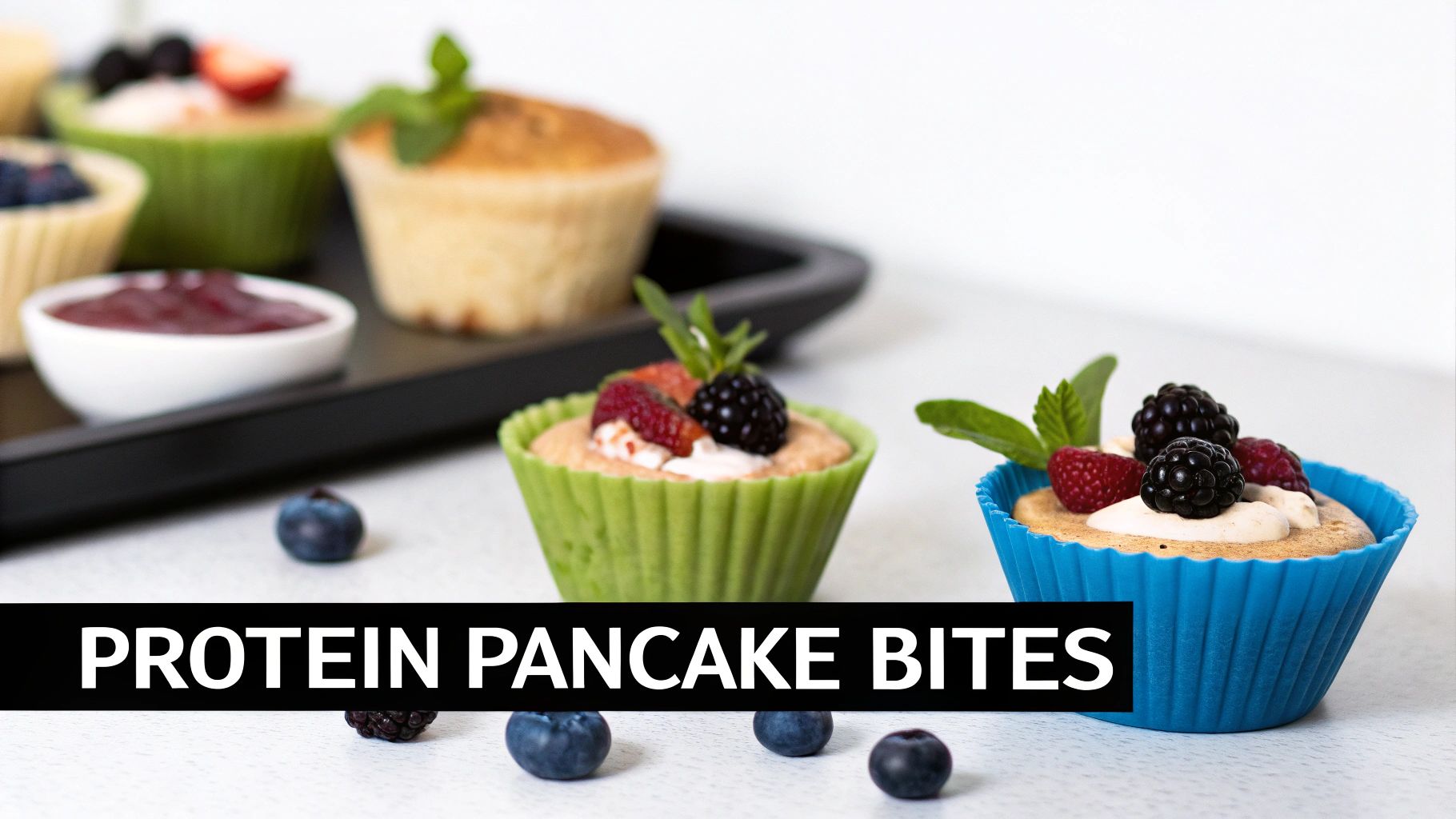 Close-up of delicious protein pancake bites in colorful silicone molds, garnished with fresh berries and mint.