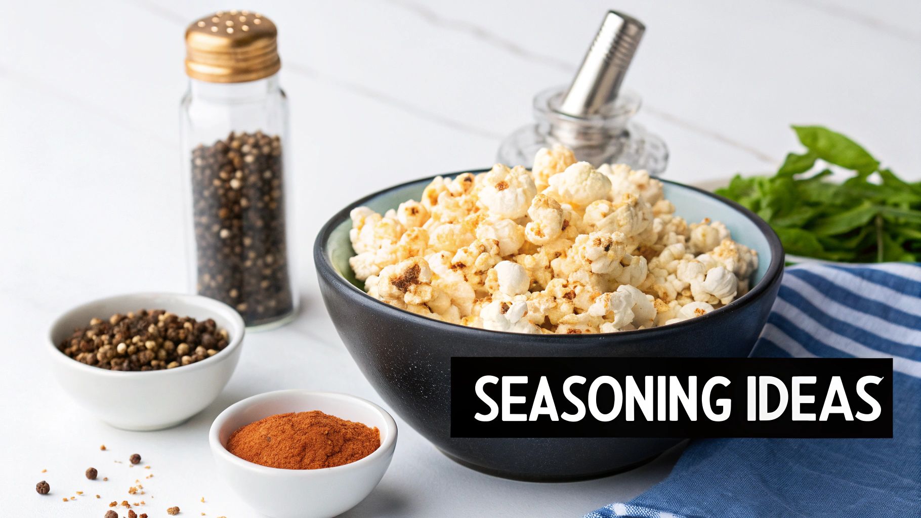 A large bowl of seasoned popcorn is surrounded by small bowls of peppercorns and paprika, with a pepper shaker.