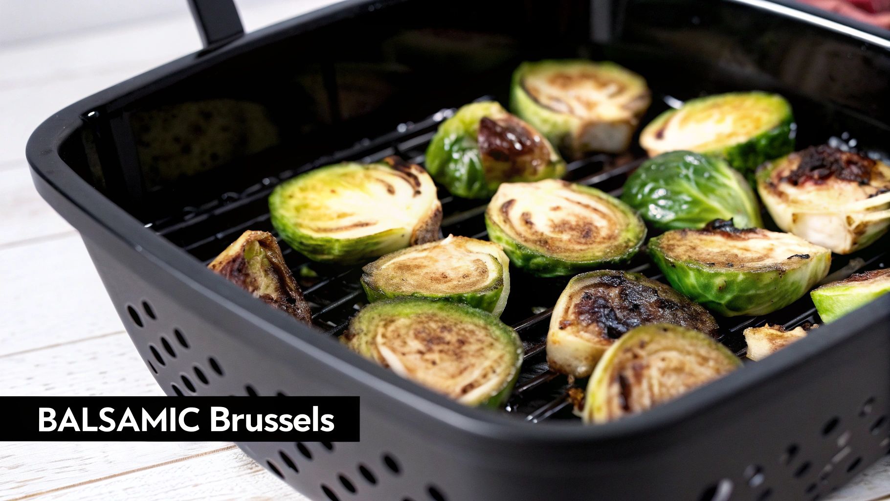 Roasted balsamic Brussels sprouts with charred edges in a black air fryer basket, ready to eat.