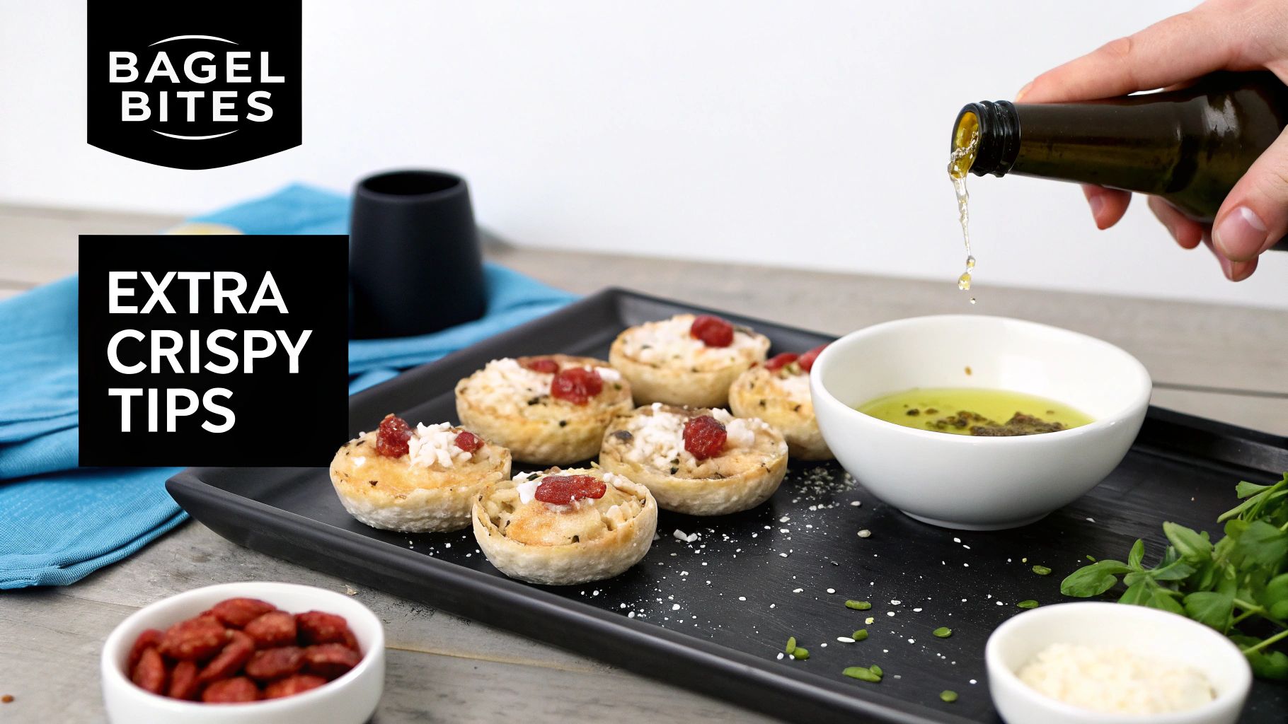 Hand pouring olive oil over crispy Bagel Bites topped with cheese and sun-dried tomatoes