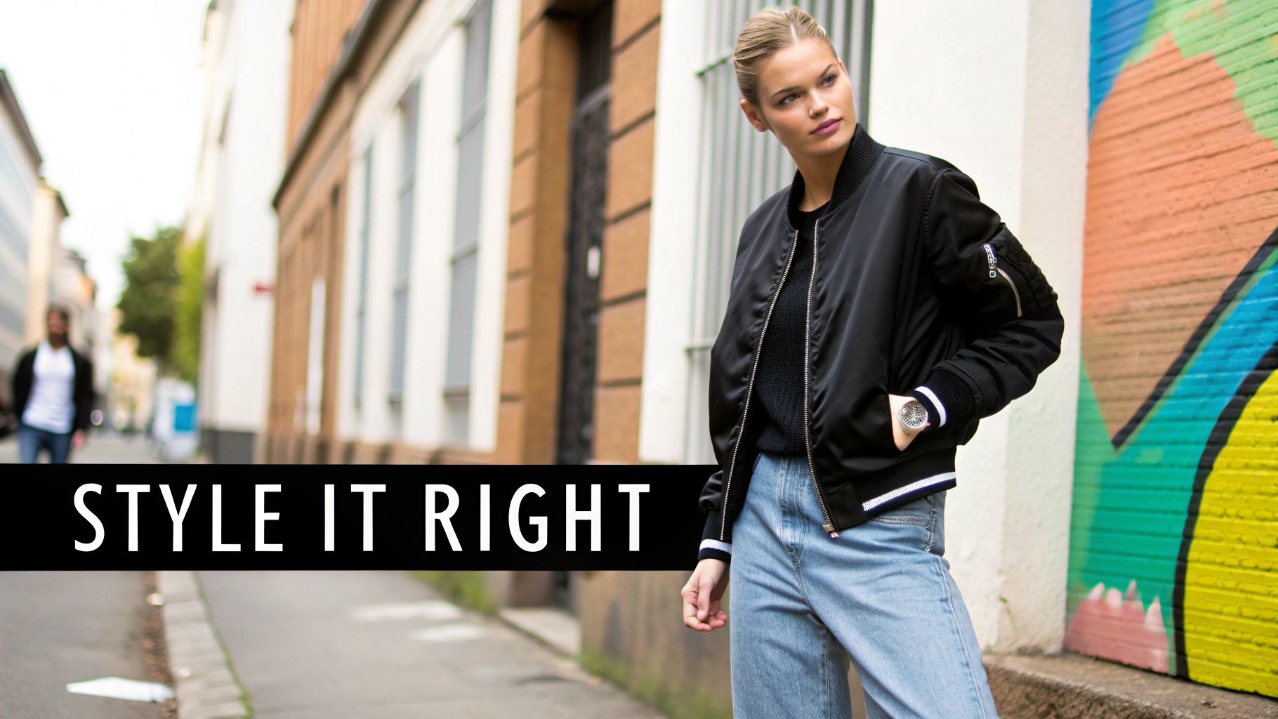 A person posing in a stylish black bomber jacket