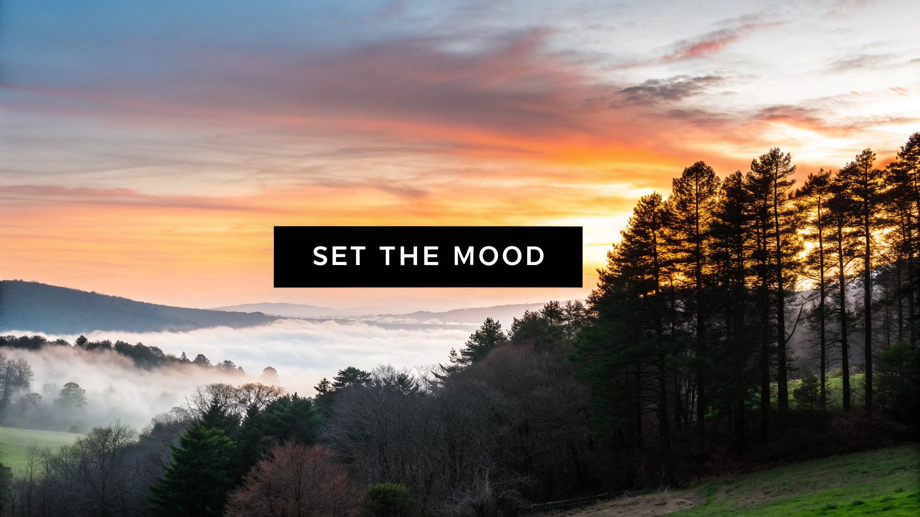 A scenic mountain landscape at sunrise or sunset with a vibrant orange sky and misty valleys.