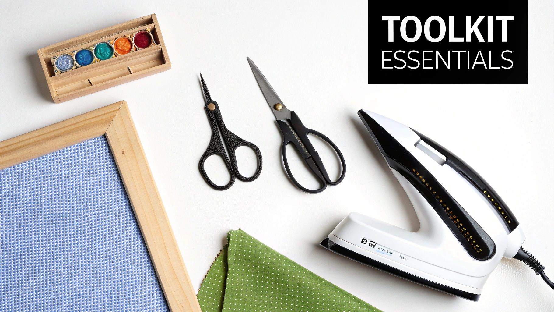A collection of cross stitch finishing tools like scissors, rulers, and mounting boards arranged on a wooden table.
