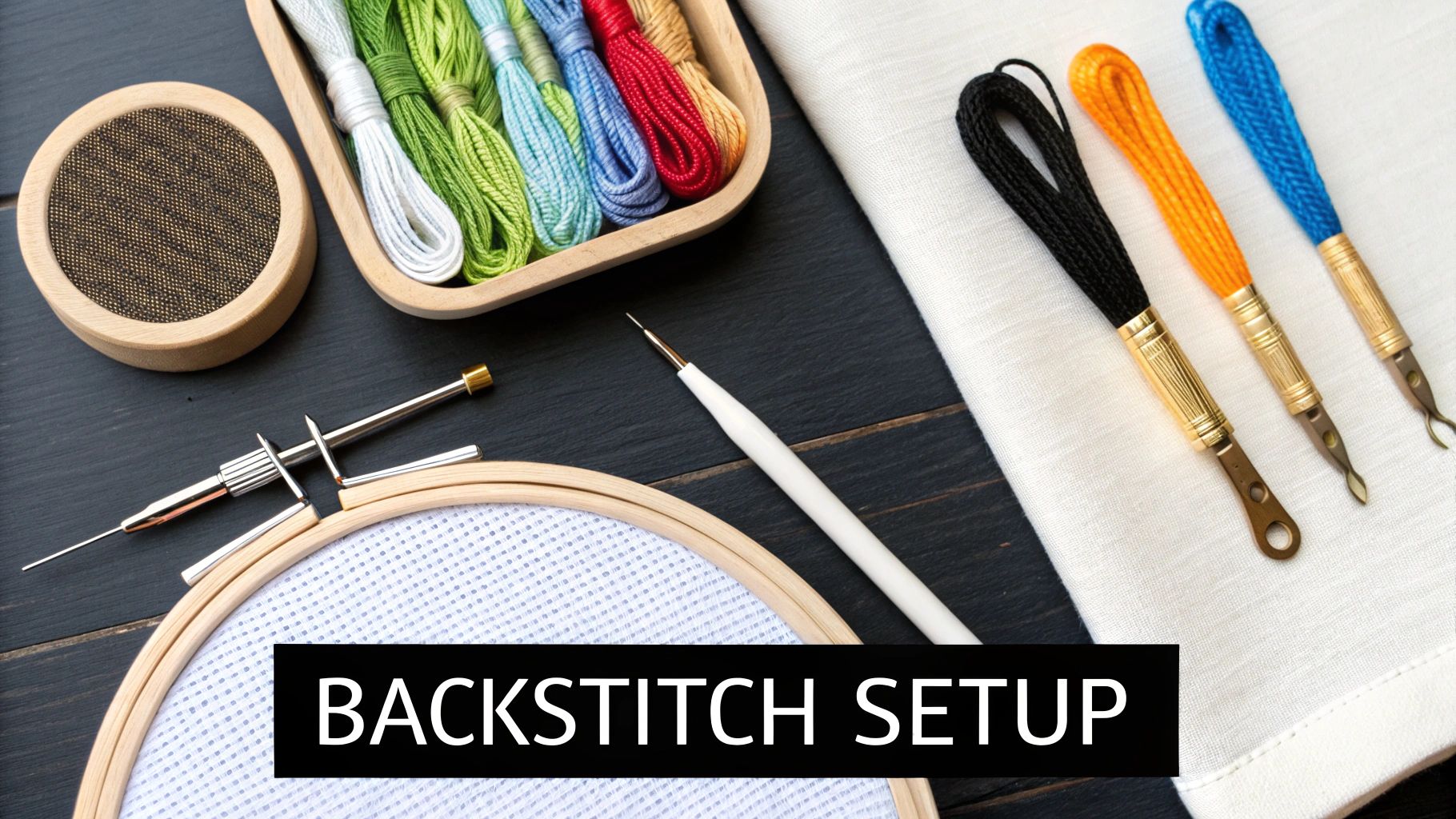 A collection of cross-stitching tools including colorful floss, needles, and fabric stretched in a hoop.