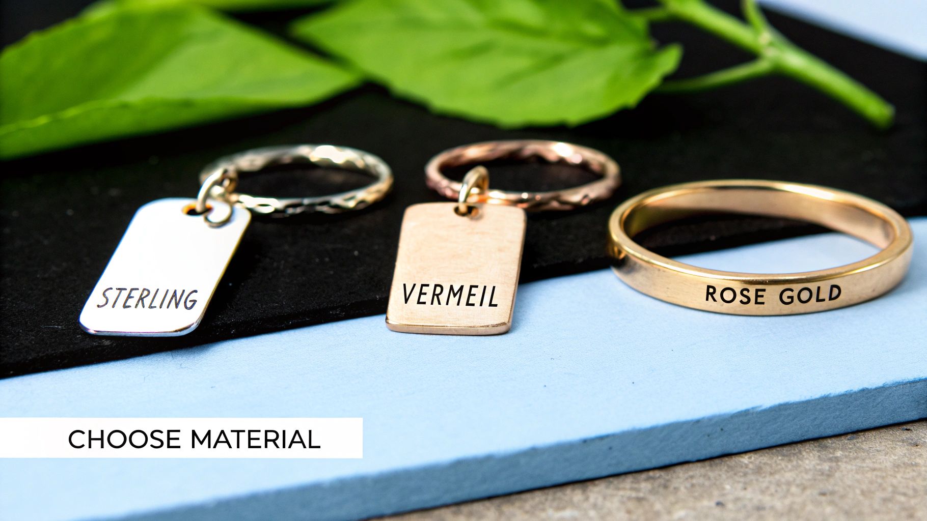 Three jewelry pieces, including a sterling silver tag, a vermeil tag, and a rose gold ring, displayed for material selection.