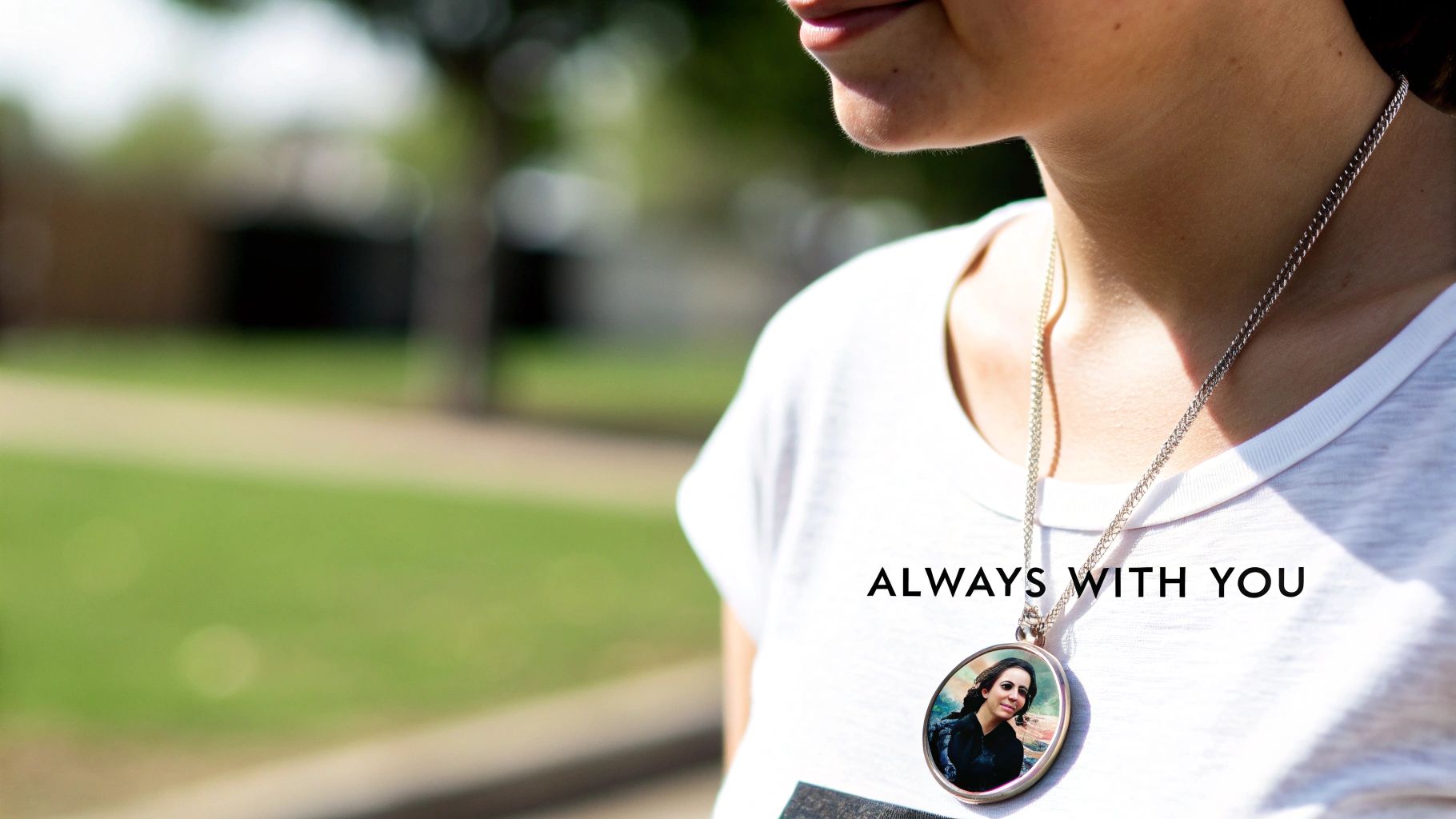 A woman holding a personalized photo pendant necklace close to her heart, showcasing the detail of the photo.