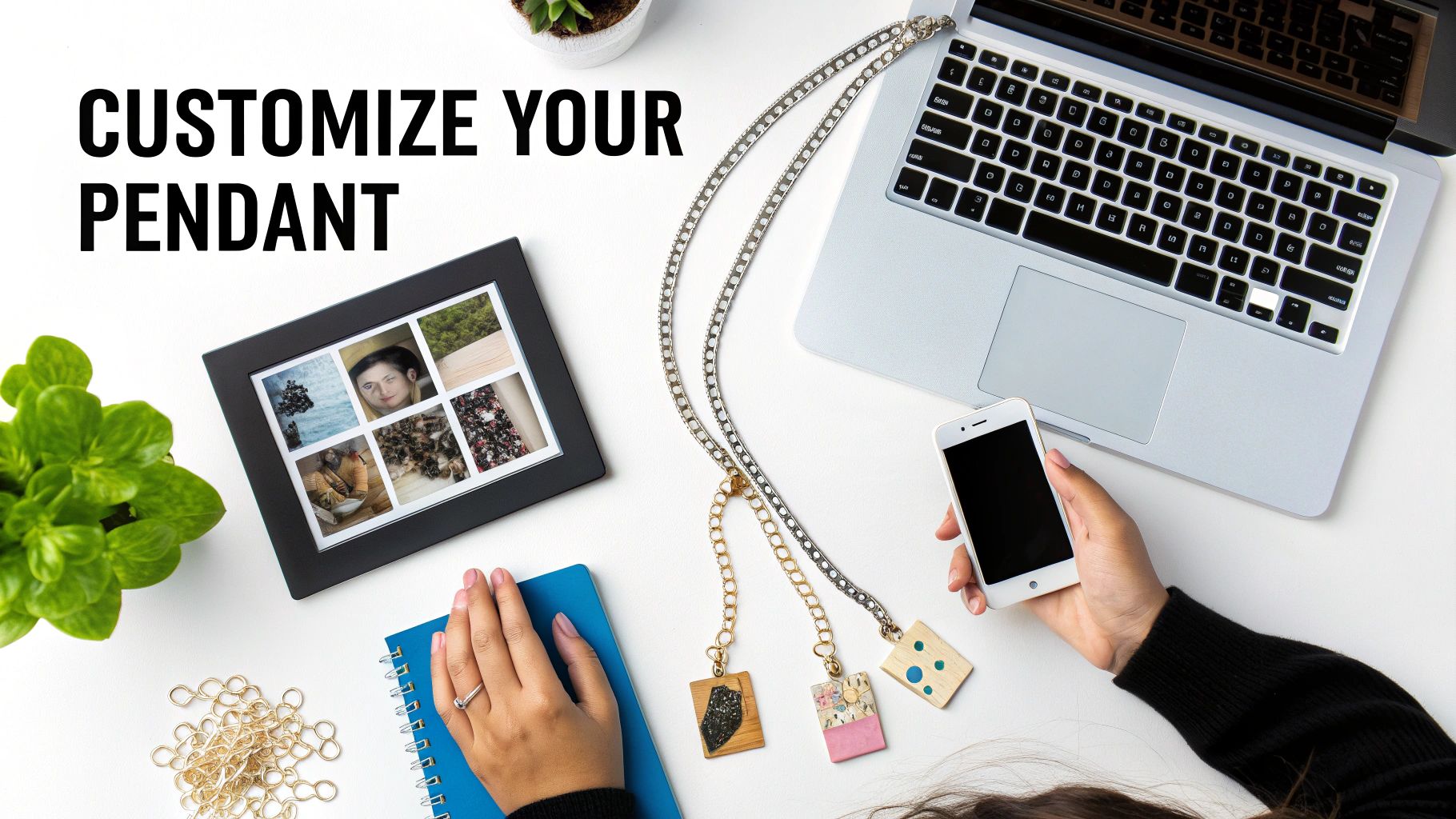 Workspace flatlay showing customizable photo pendant necklaces, laptop, smartphone, and craft supplies on white desk