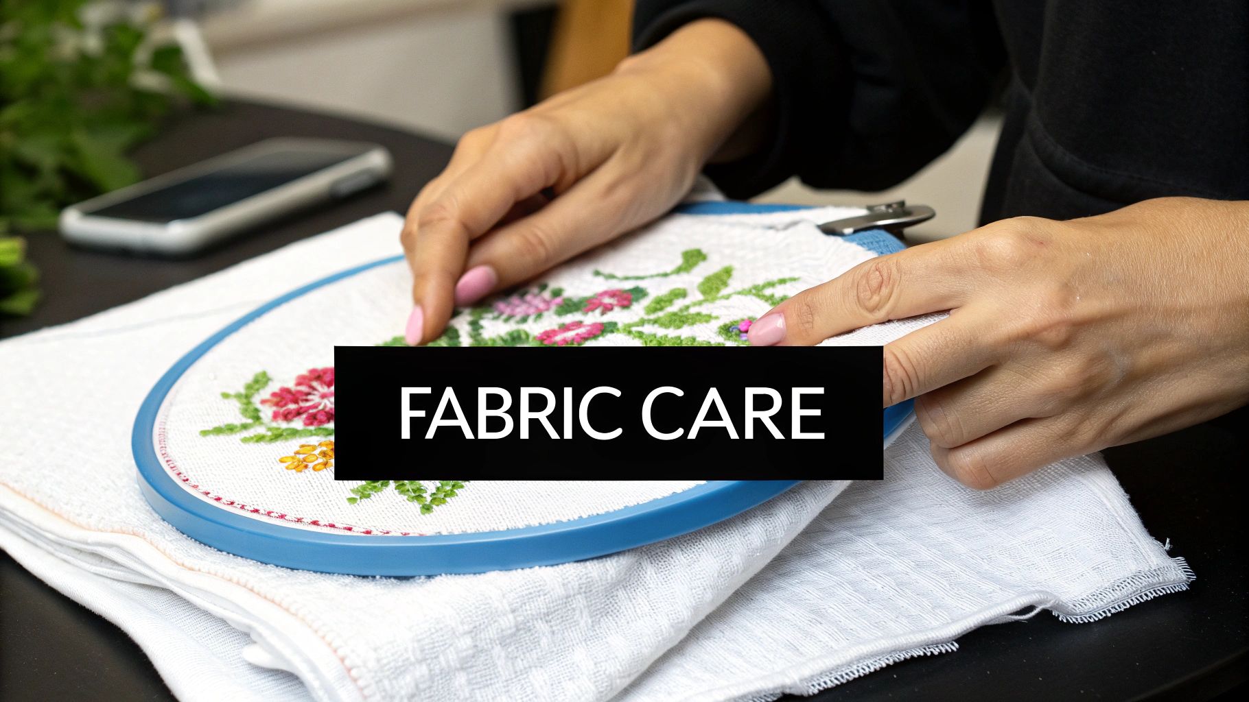 Close-up of hands working on an embroidery hoop with a beautiful floral design on white fabric.